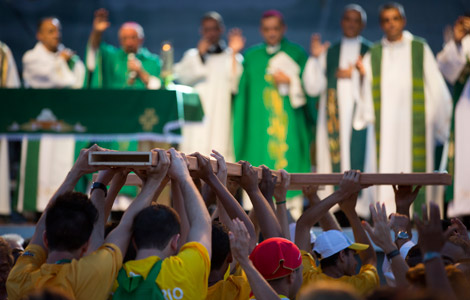 Pilgrims carry a cross to the altar during a Mass at the close of World Youth Day's missionary week in Nilopolis, Brazil. (CNS photo/Tyler Orsburn)