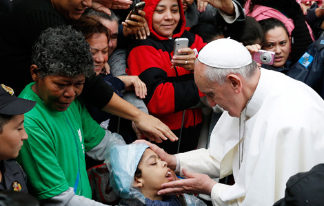 Pope Francis blesses a boy in the Varginha slum in Rio de Janeiro. (CNS photo/Paul Haring)