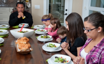A family prays before a meal. iStock photo used for illustrative purposes only; persons depicted are models.