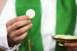 A priest holds the Eucharist. A priest holds the Eucharist.