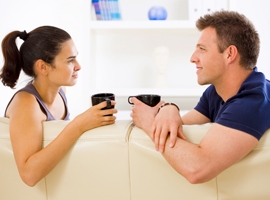 A couple talks while enjoying coffee.