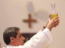 Deacon Raymond D'Alessio of St. Edward the Confessor Parish in Syosset, N.Y., holds a decanter containing the oil of the sick during the annual chrism Mass at St. Agnes Cathedral in Rockville Centre, N.Y., in 2014. CNS photo/Gregory A. Shemitz