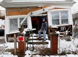 Staten Island Catholic Rudy Mienert stands outside his destroyed home. CNS Photo/Bob Roller.