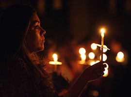 Candles provide the only light at the start of the Easter Vigil at the Shrine of the Sacred Heart in Washington, D.C. in April 2010. CNS photo/Nancy Wiechec