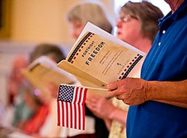 A man holds a program and U.S. flag during the opening Mass for the second annual Fortnight for Freedom observance on June 21. (CNS photo/Tom McCarthy Jr., Catholic Review)