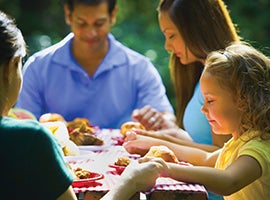 A family says grace together before a meal.