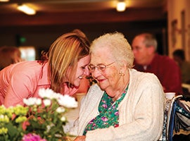 A grandmother and grandaughter share a moment together.