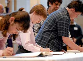 Young people sign the Book of the Elect during a 2009 Rite of Election ceremony for catechumens and candidates at Sacred Heart Cathedral in Rochester, N.Y.  CNS photo/Mike Crupi, Catholic Courier