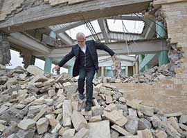 Father Emanuel Youkhana, an archimandrite of the Assyrian Church of the East, walks through the rubble of a demolished church in Mosul, Iraq, in January 2017. (CNS photo/Paul Jeffrey