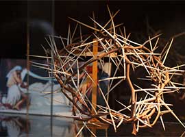 An image of Jesus in death is seen behind a crown of thorns and a crucifix in a display on the Shroud of Turin in Turin, Italy. CNS photo/Paul Haring