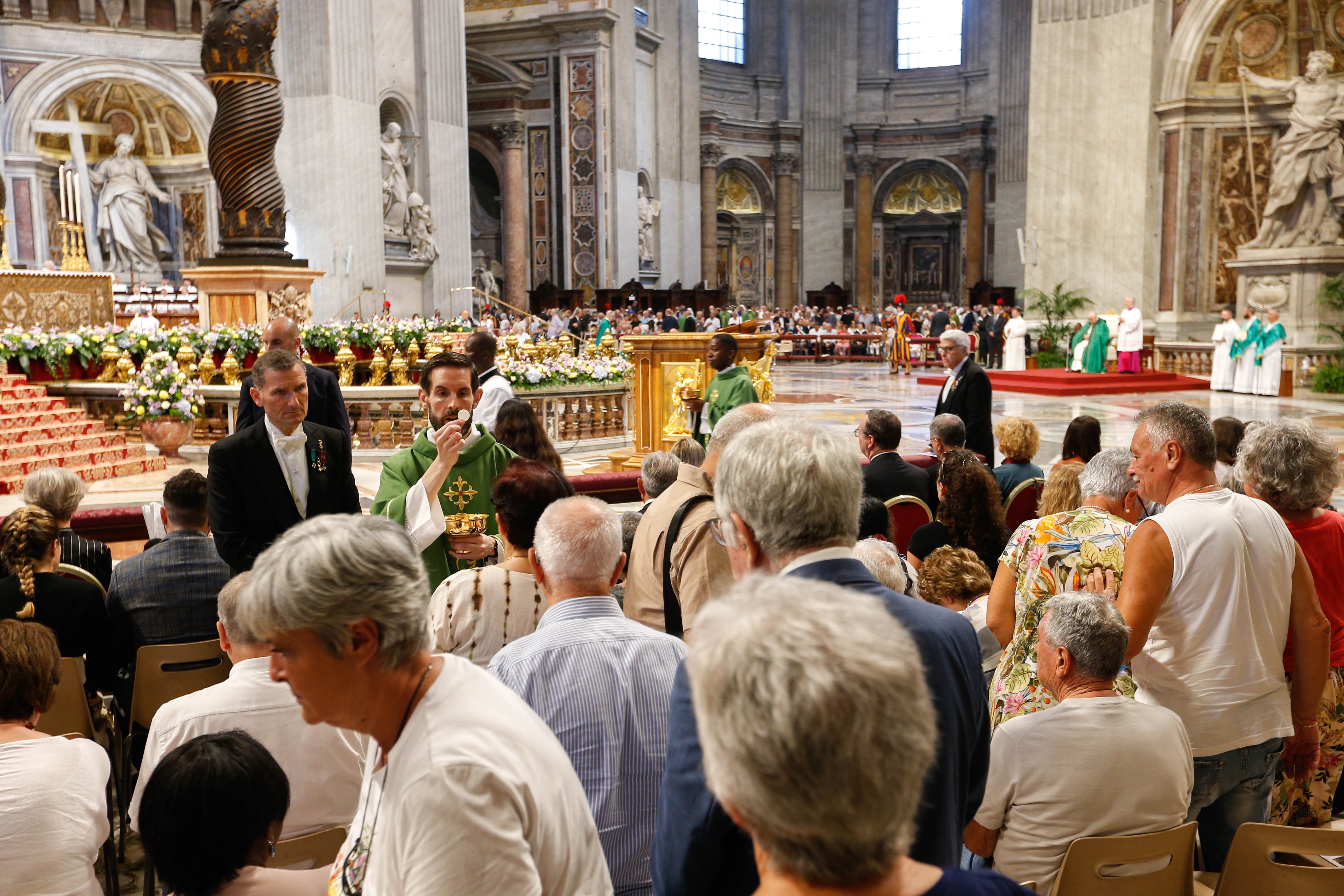 People receive Communion in St. Peter's Basilica.