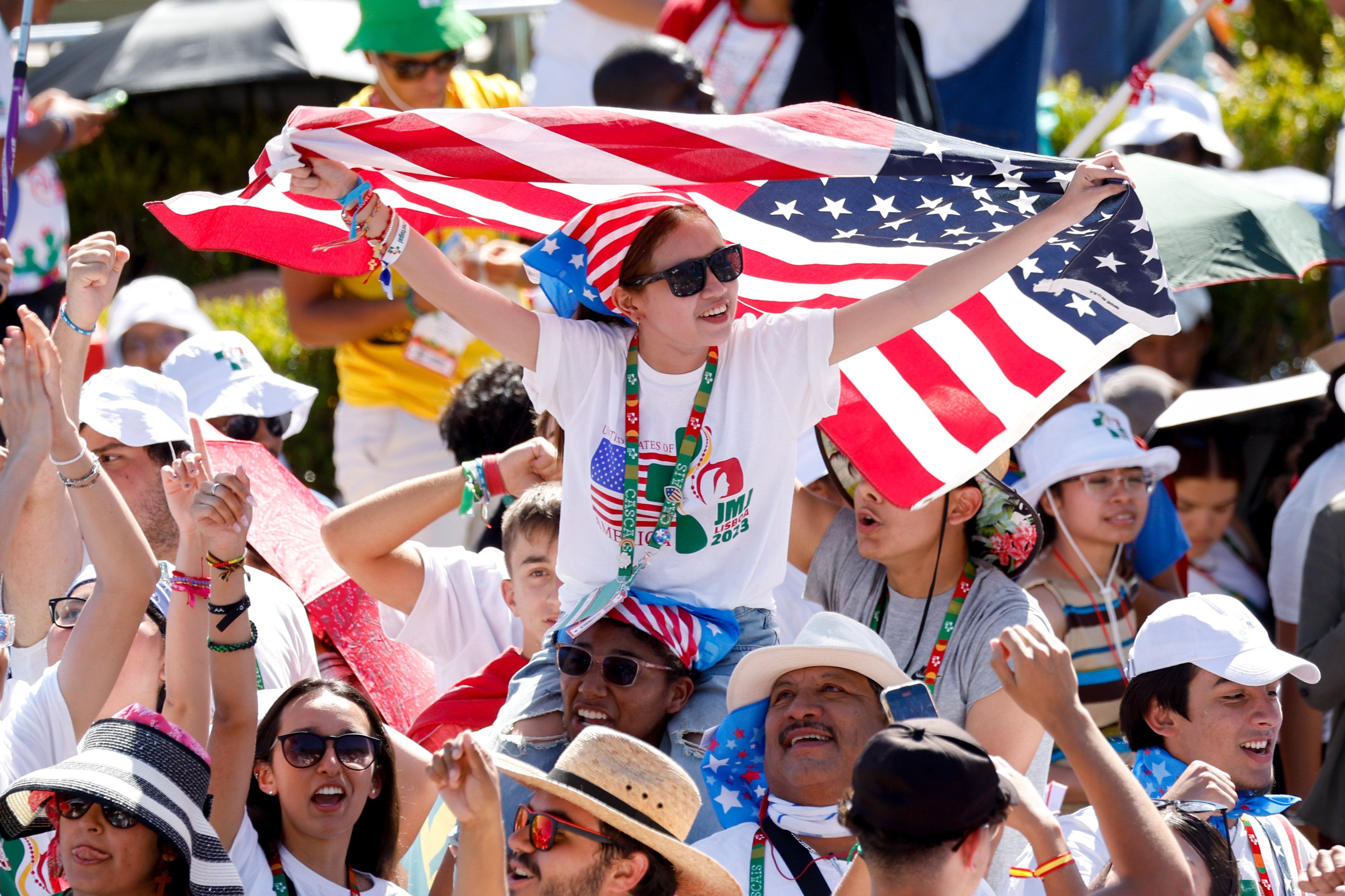 Woman holds American flag in crowd.