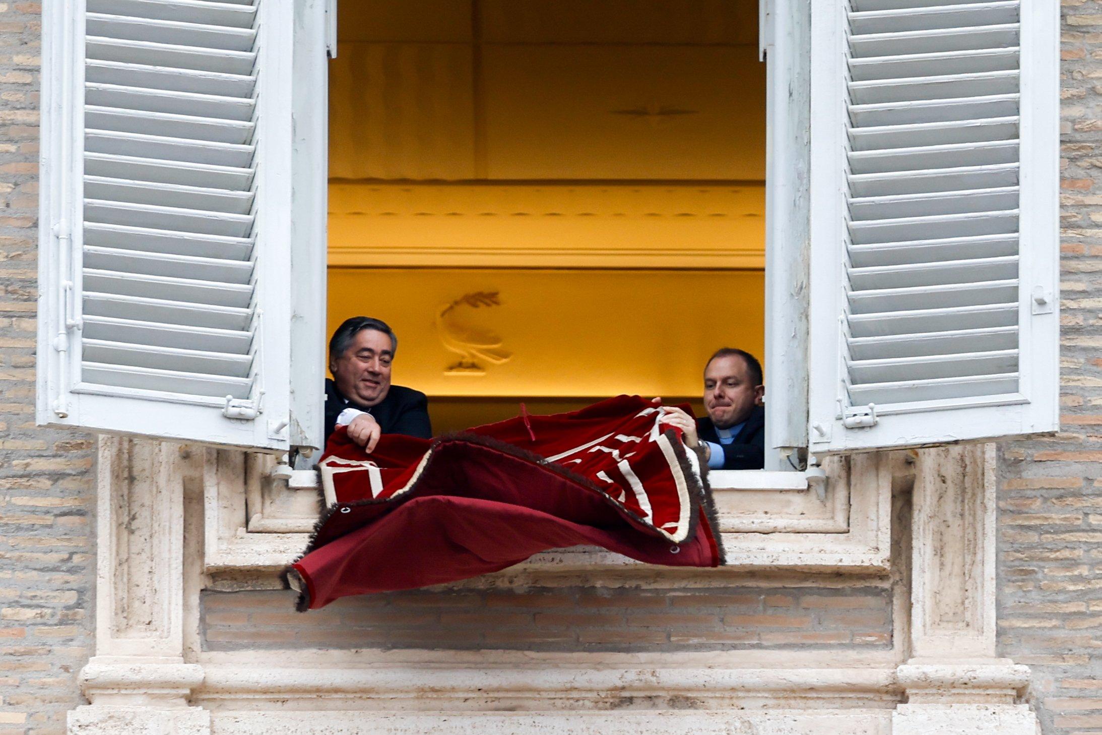 Workers hang papal tapestry