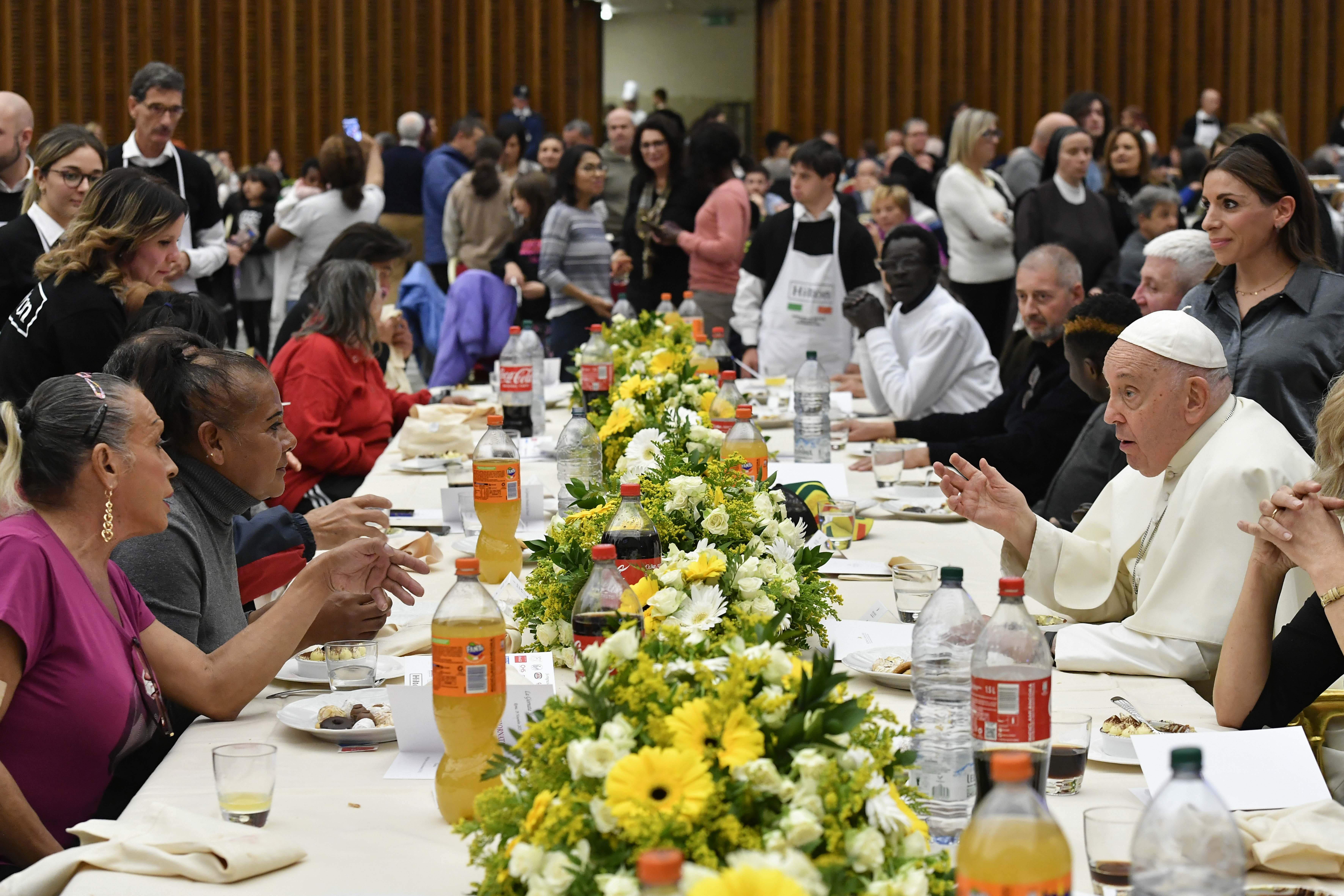 Pope Francis eats lunch with his guests in the Vatican audience hall.