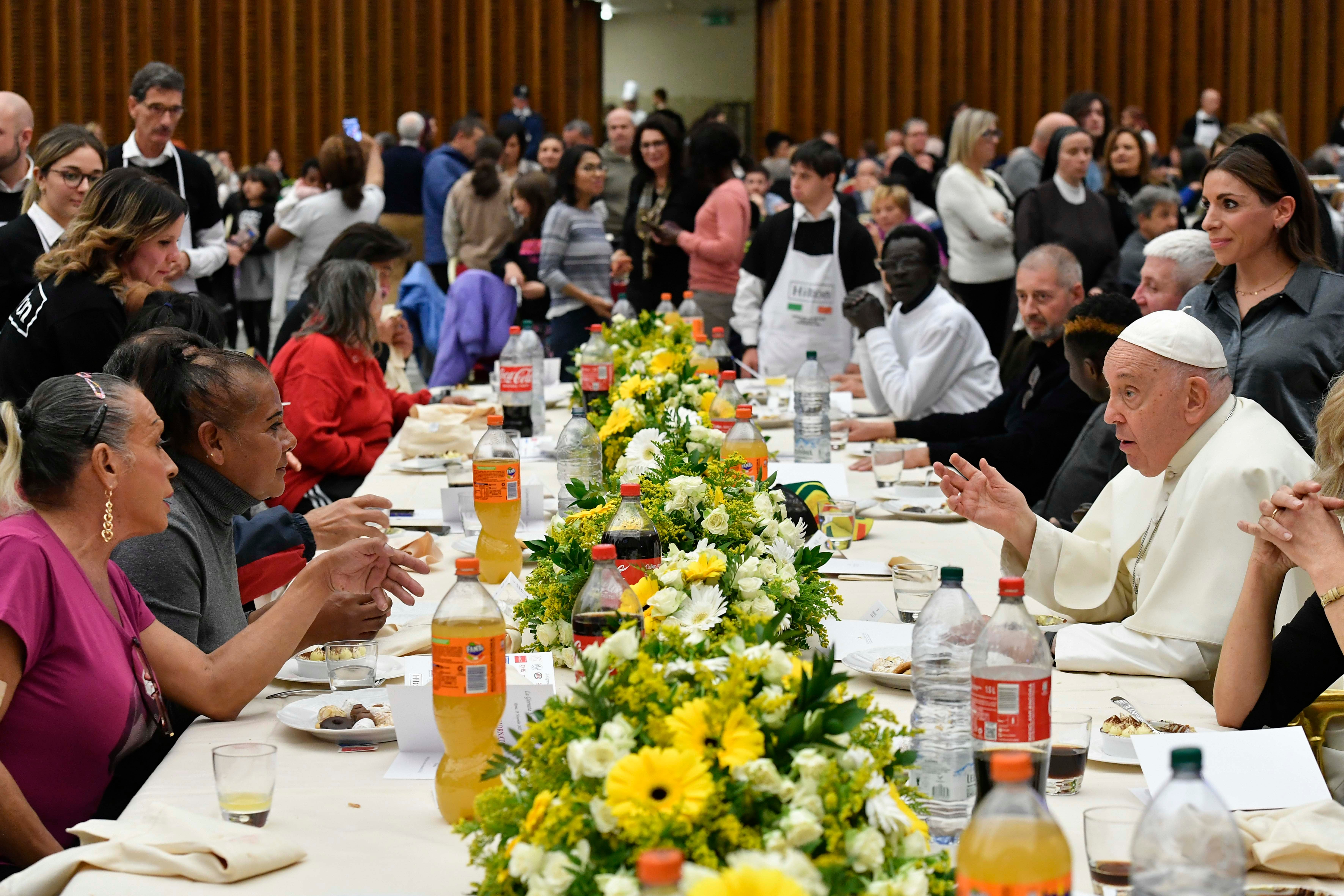 Pope Francis eats lunch with his guests in the Vatican audience hall.