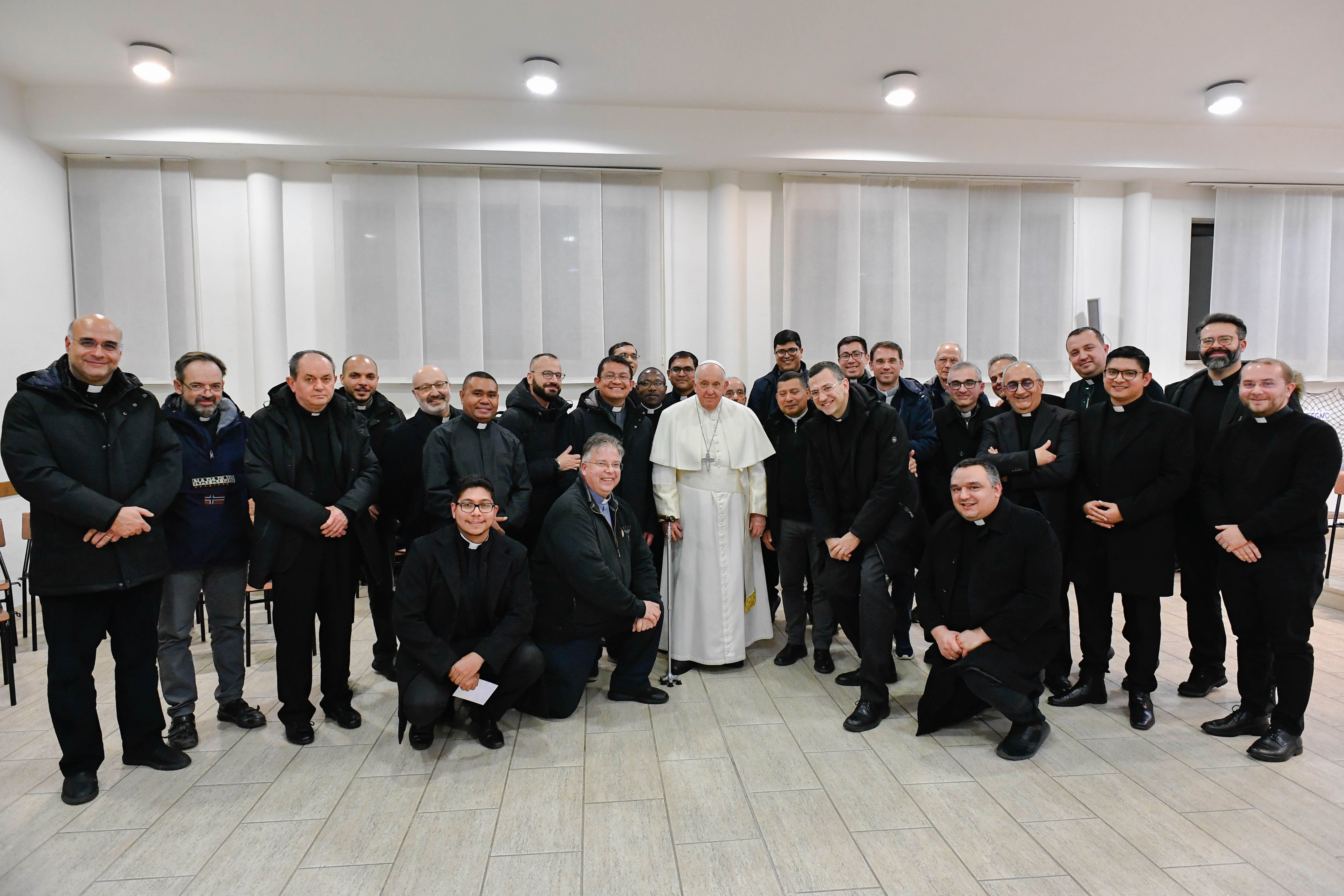 Pope Francis poses for a photo with a group of priests. 