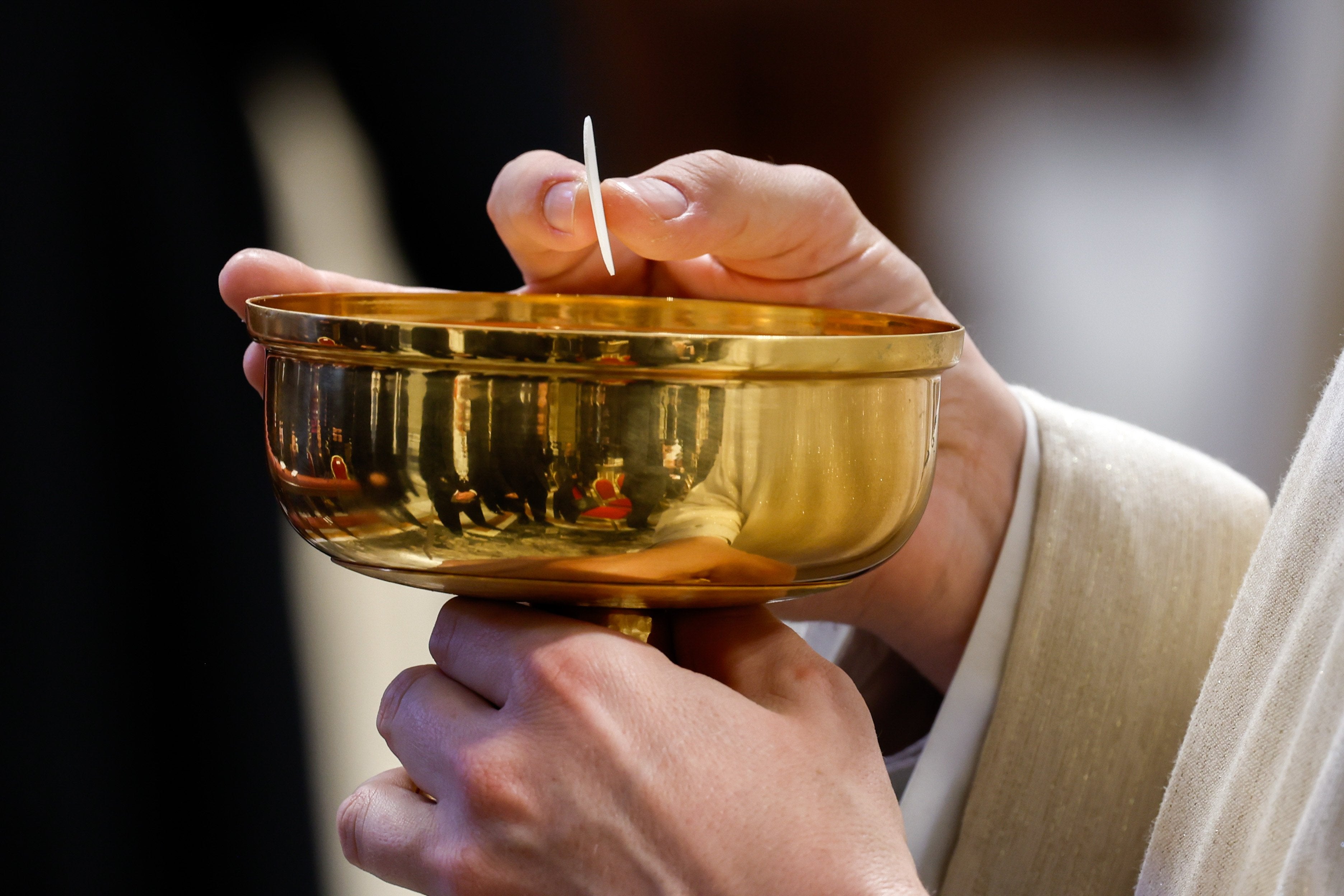 A priest distributes Communion during Pope Francis’ Mass.
