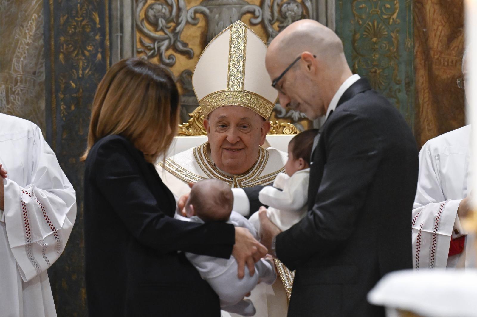 Pope Francis smiles at baptized twins