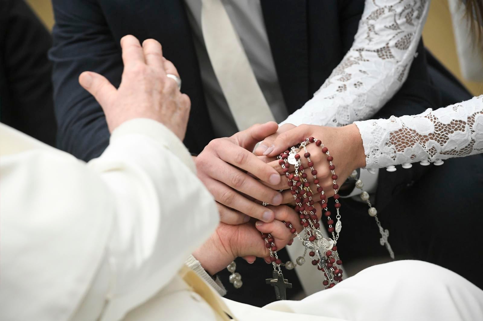 Pope Francis shakes hands with a bride.