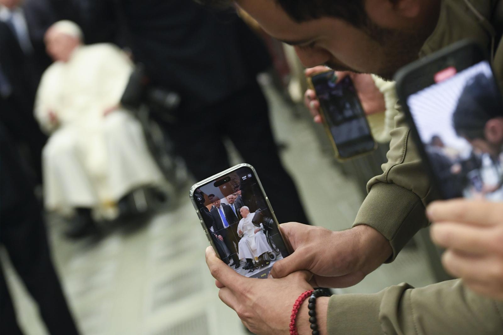 Visitors take pictures of Pope Francis.