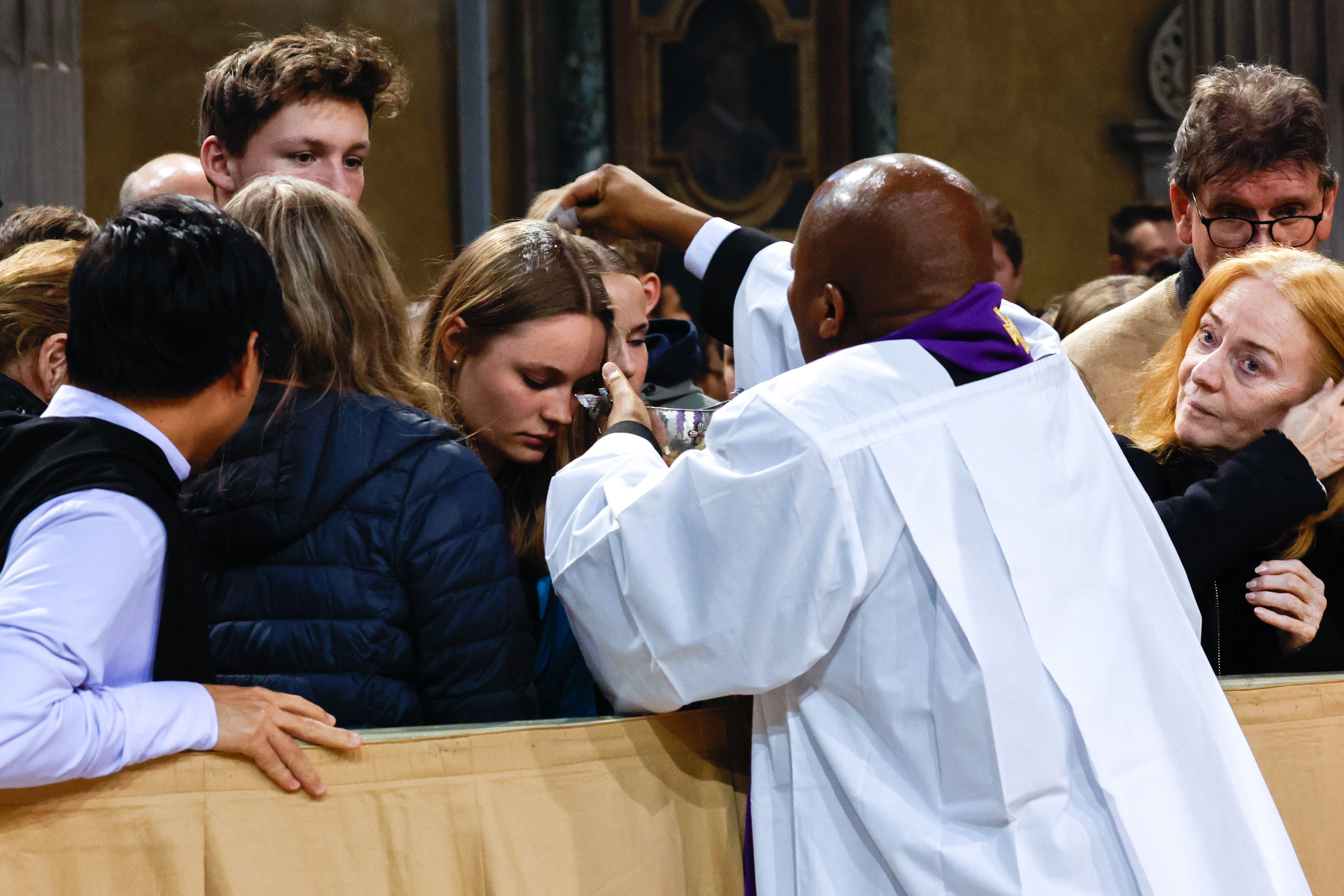 A priest administers ashes.