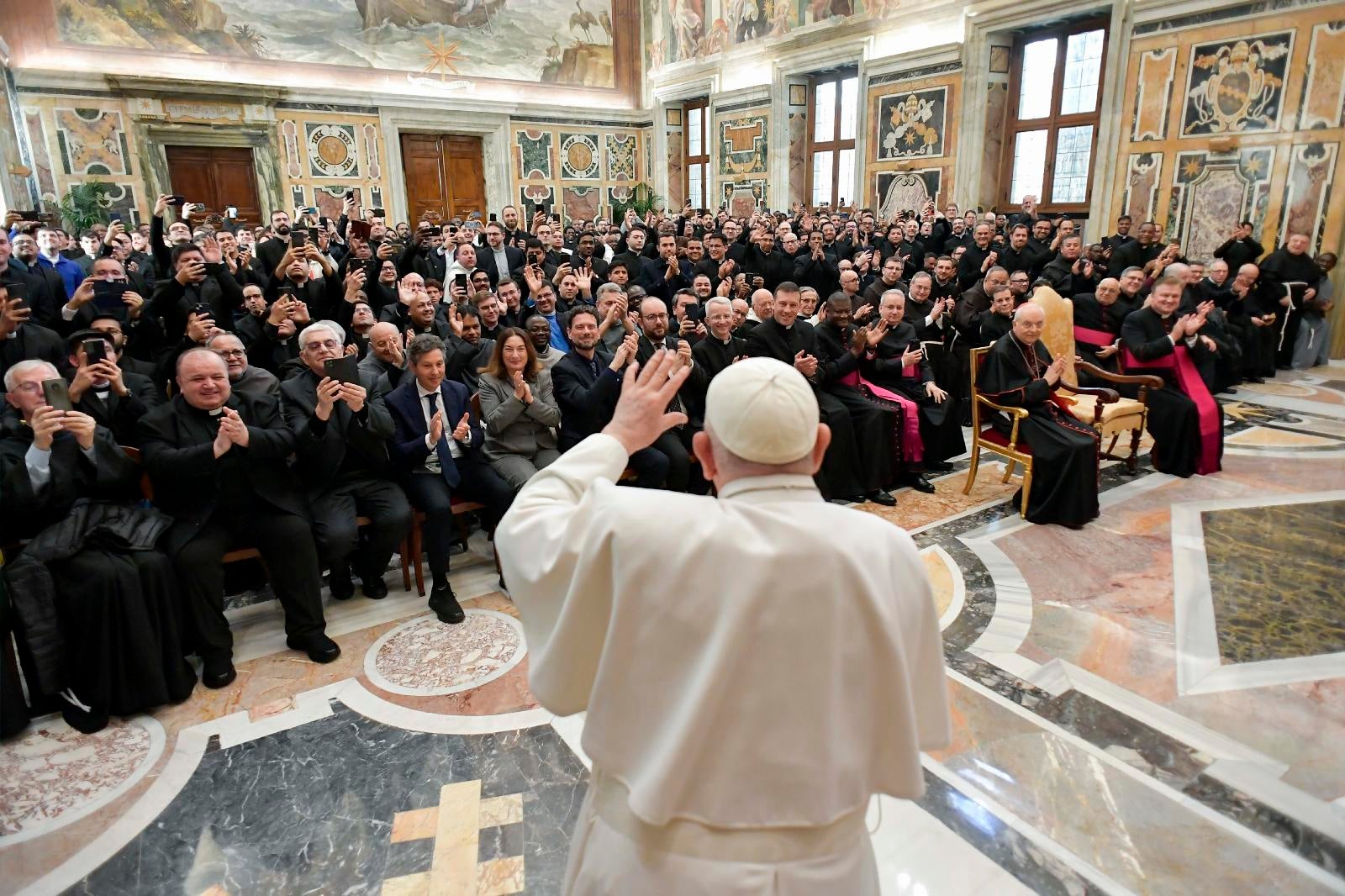 Pope Francis waves to priests at audience