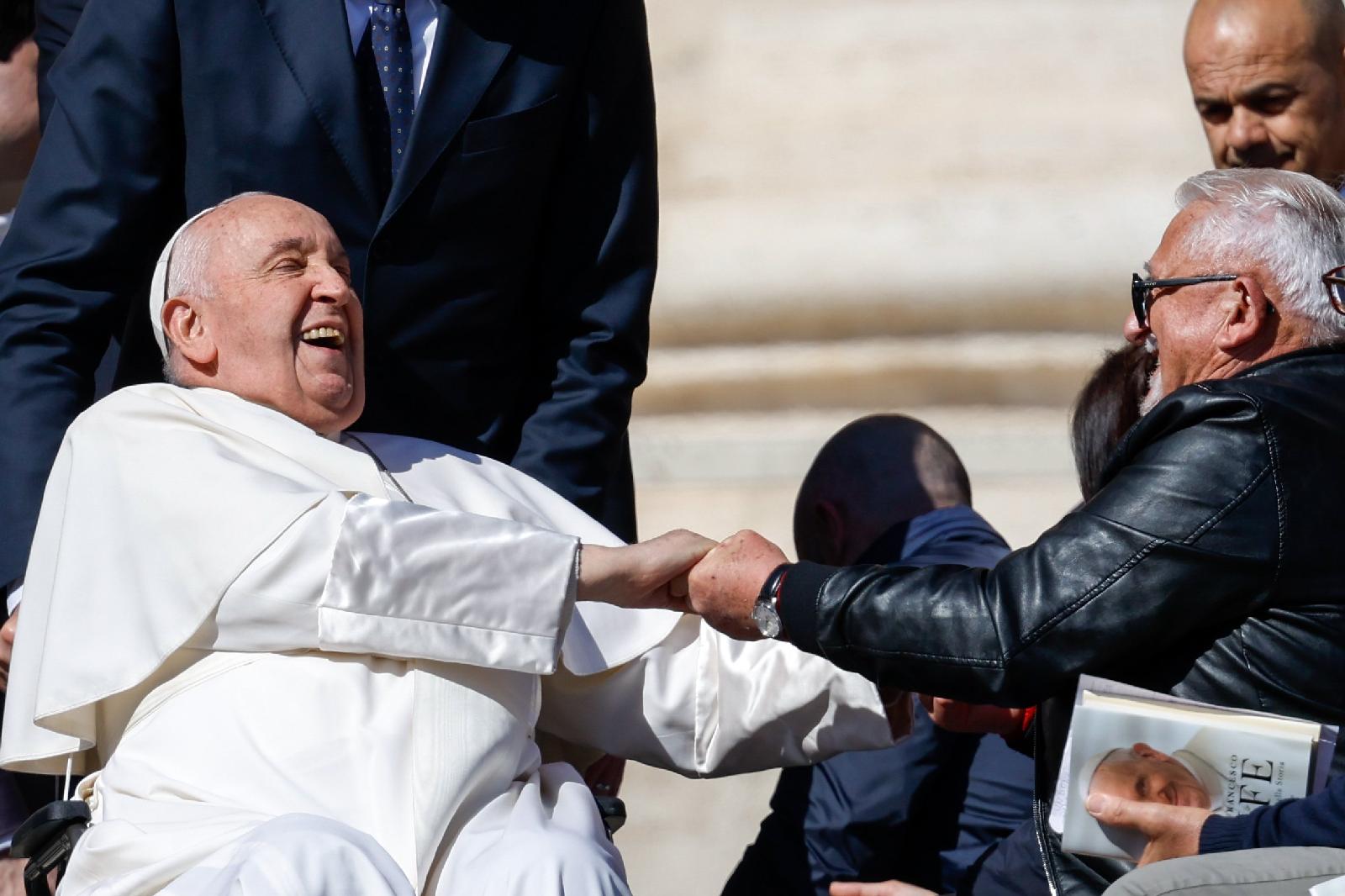 Pope Francis laughs with a visitor