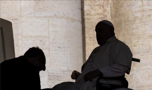 Aide helps Pope Francis in his wheelchair