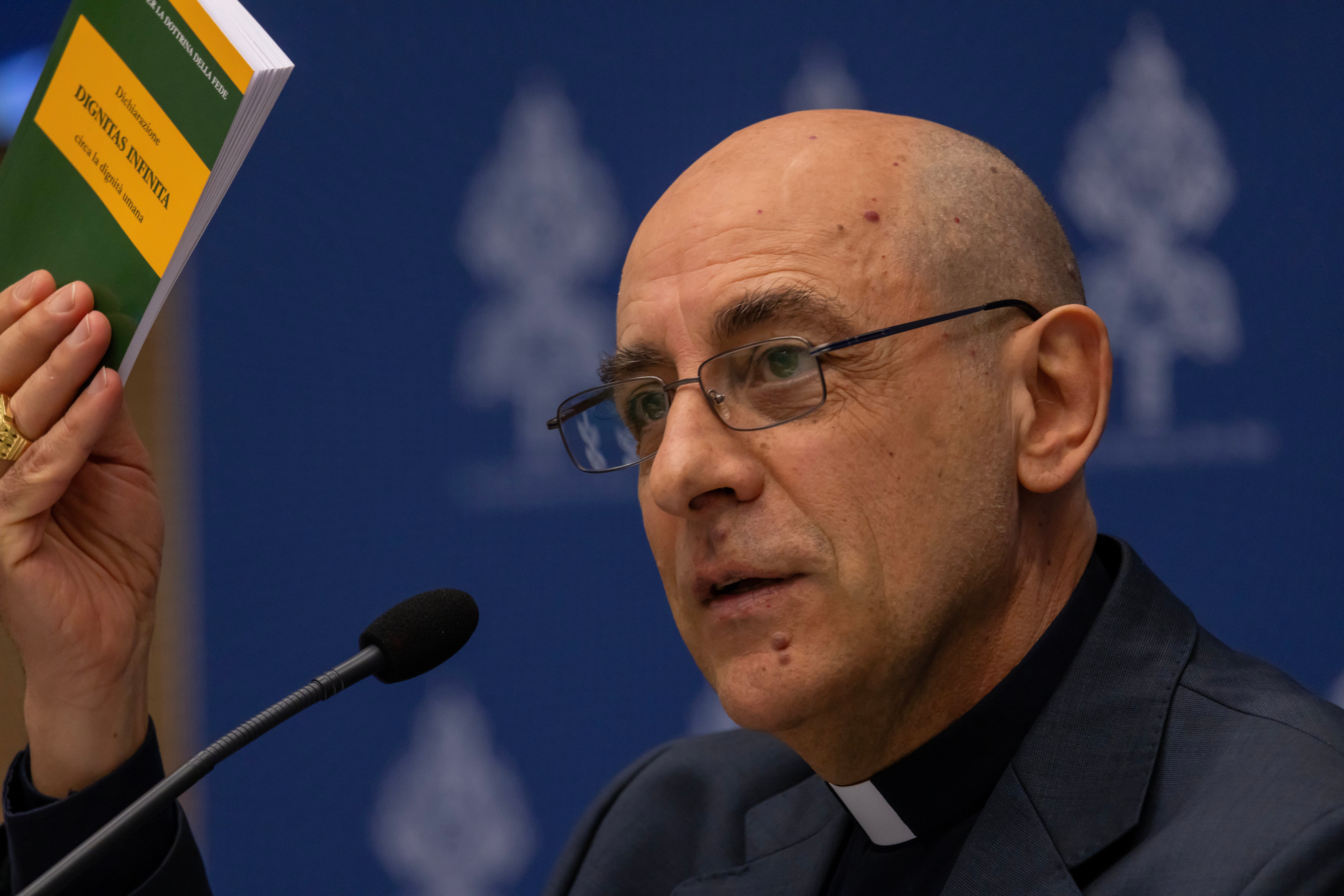 Cardinal Víctor Manuel Fernández, prefect of the Dicastery for the Doctrine of the Faith, holds up a copy of the dicastery's declaration, 