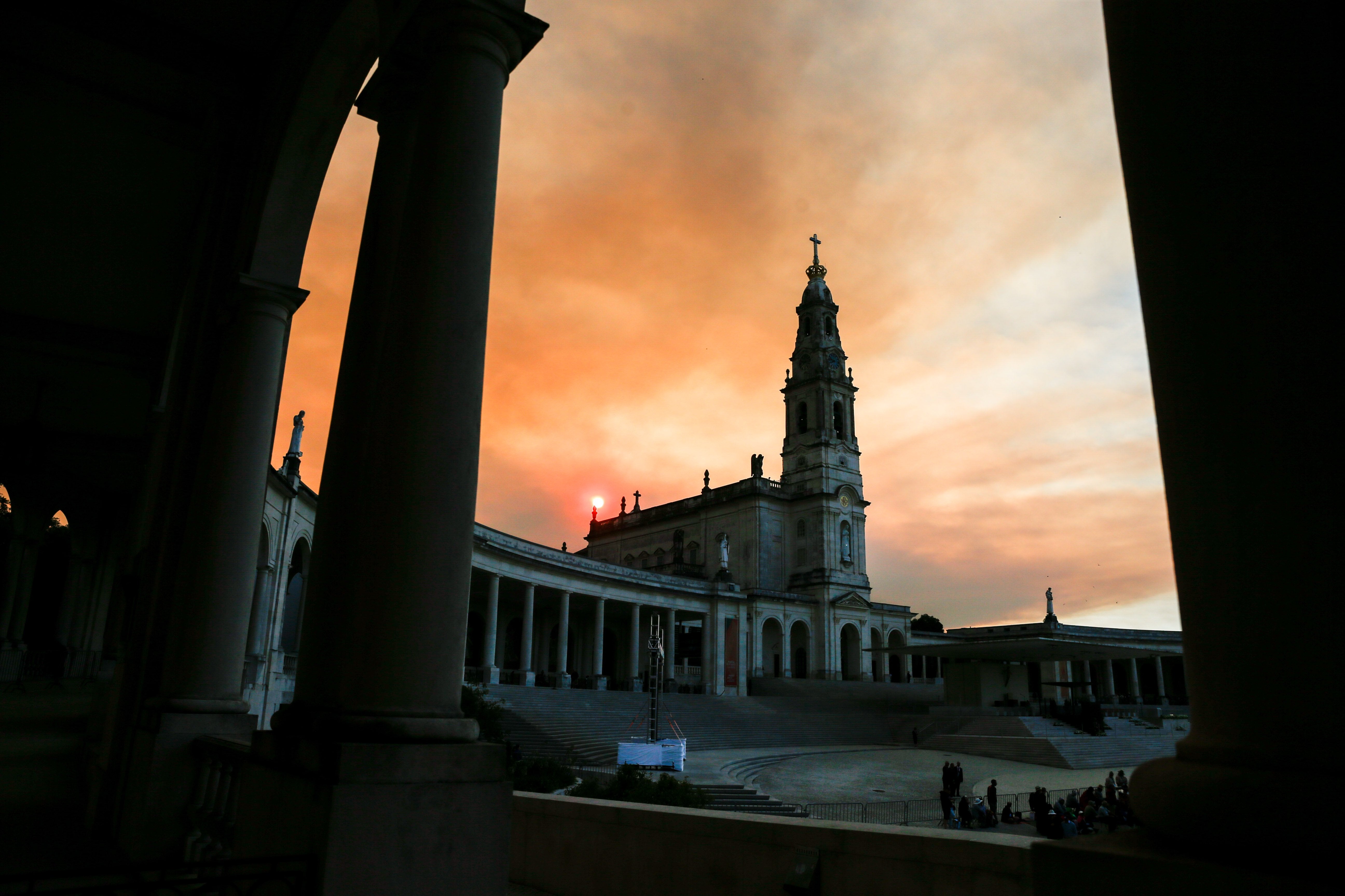 The sun rises behind the Shrine of Our Lady of Fátima in Fátima, Portugal.