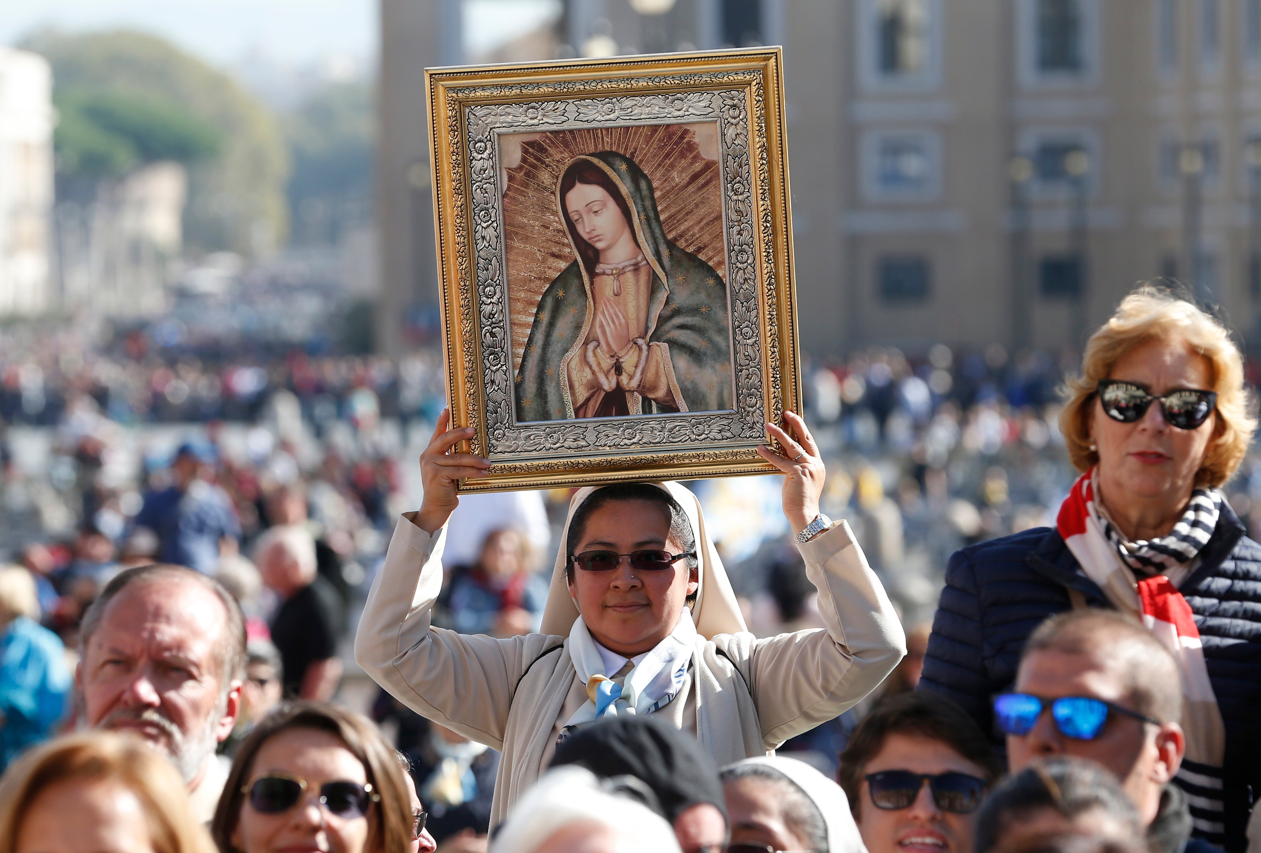 A religious sister holds an image of Our Lady of Guadalupe.