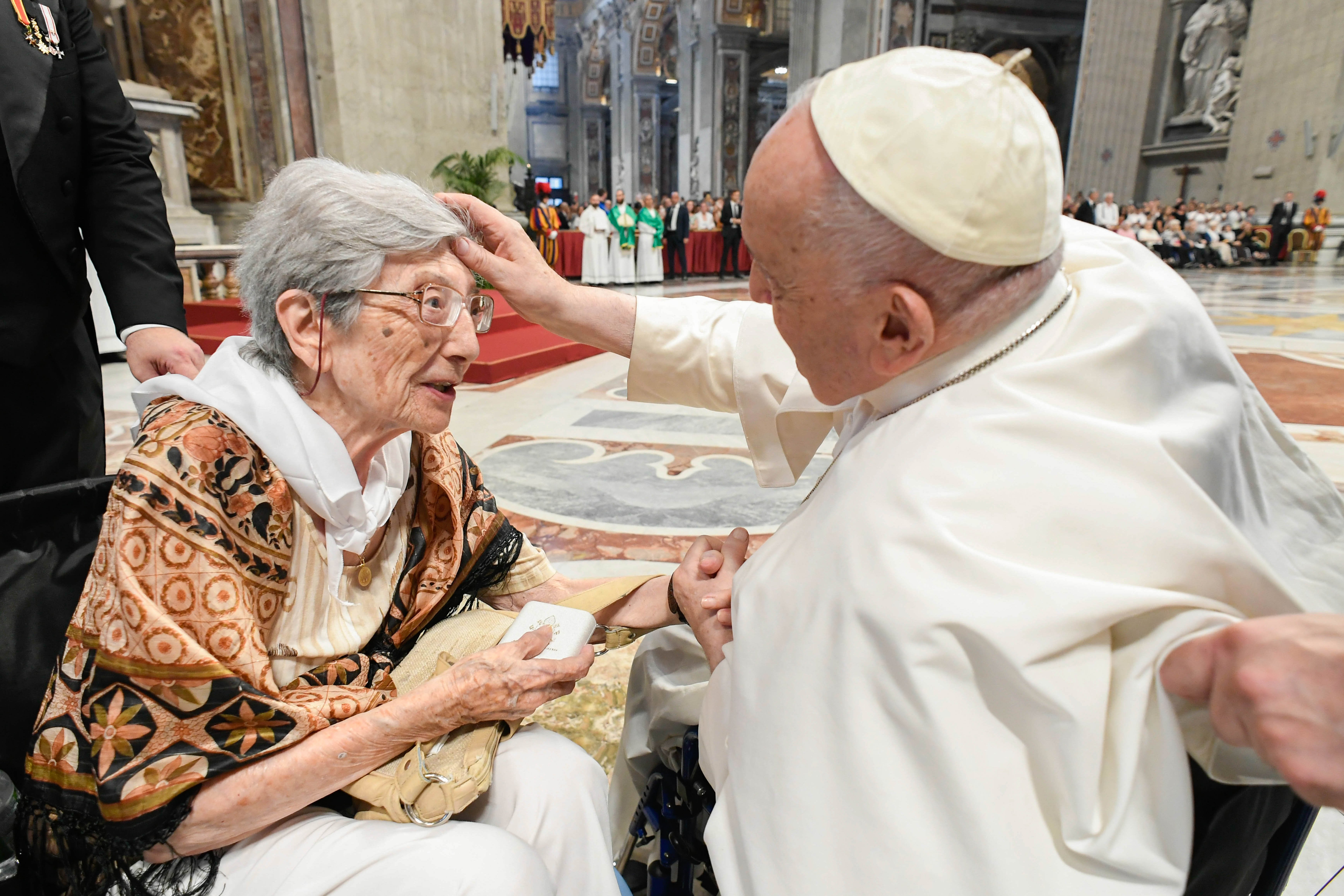 Pope Francis blesses an elderly woman. 