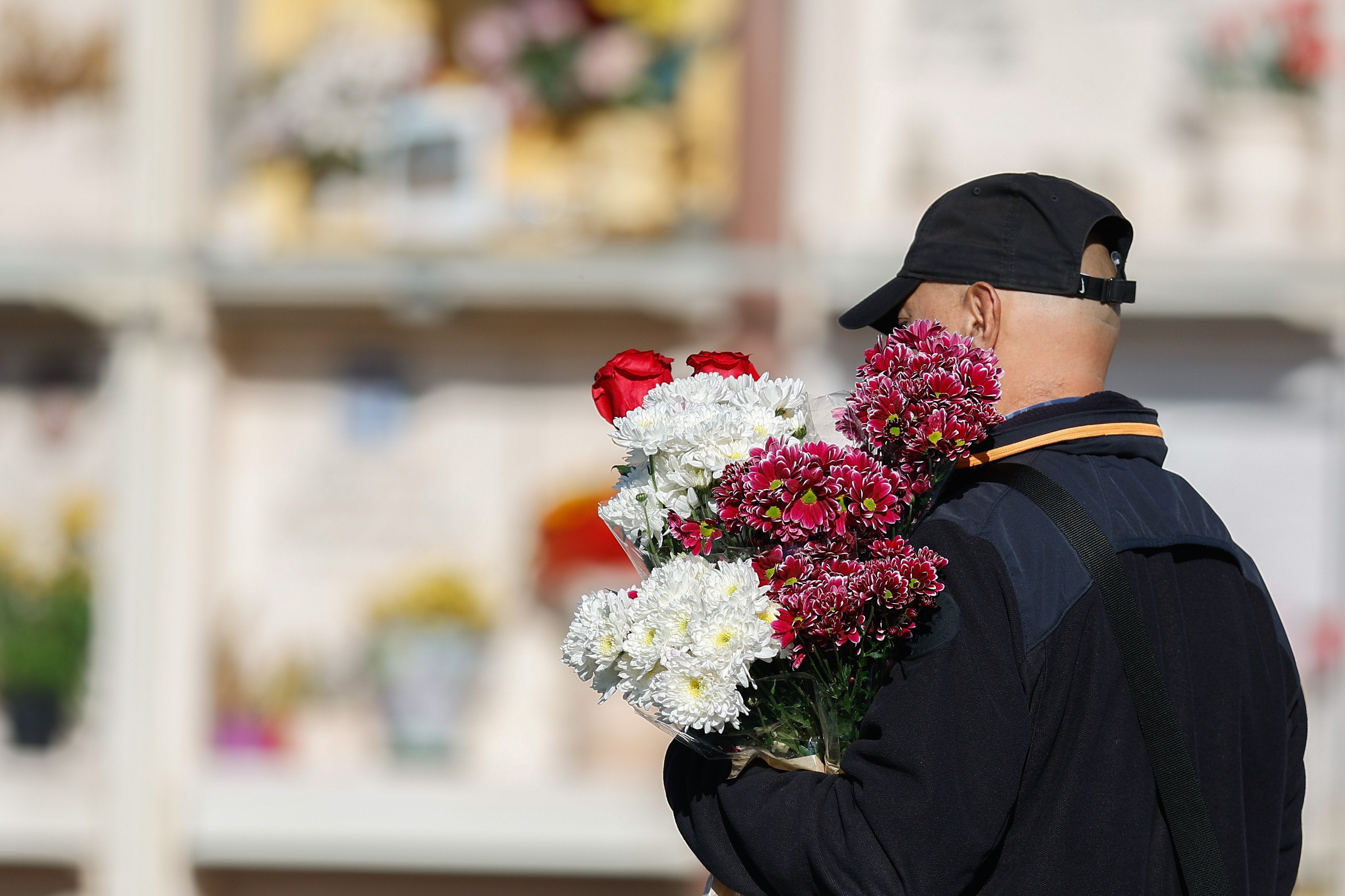 A man brings flowers to a mausoleum
