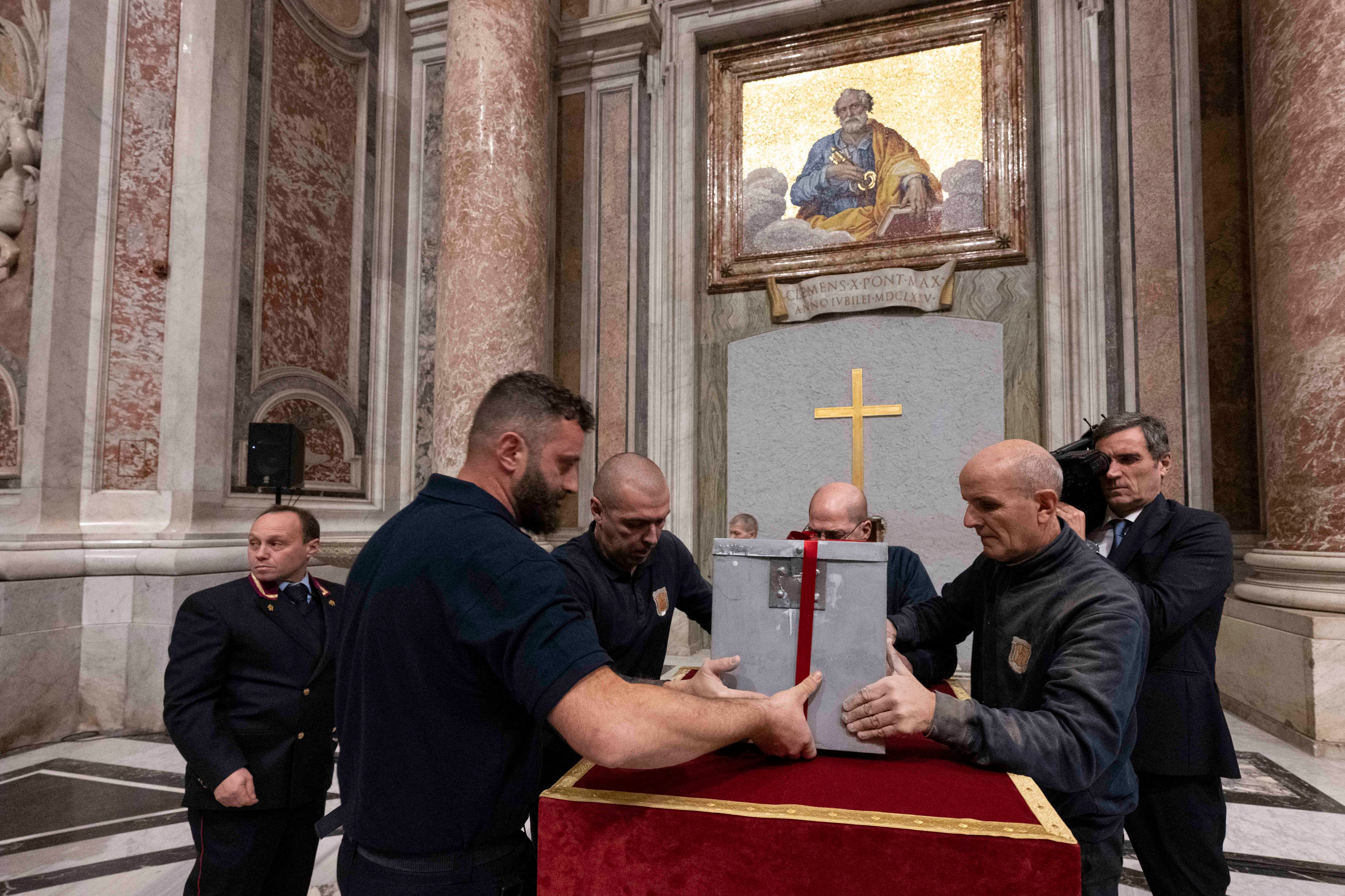 Workers take a box from the sealed Holy Door at St. Peter's