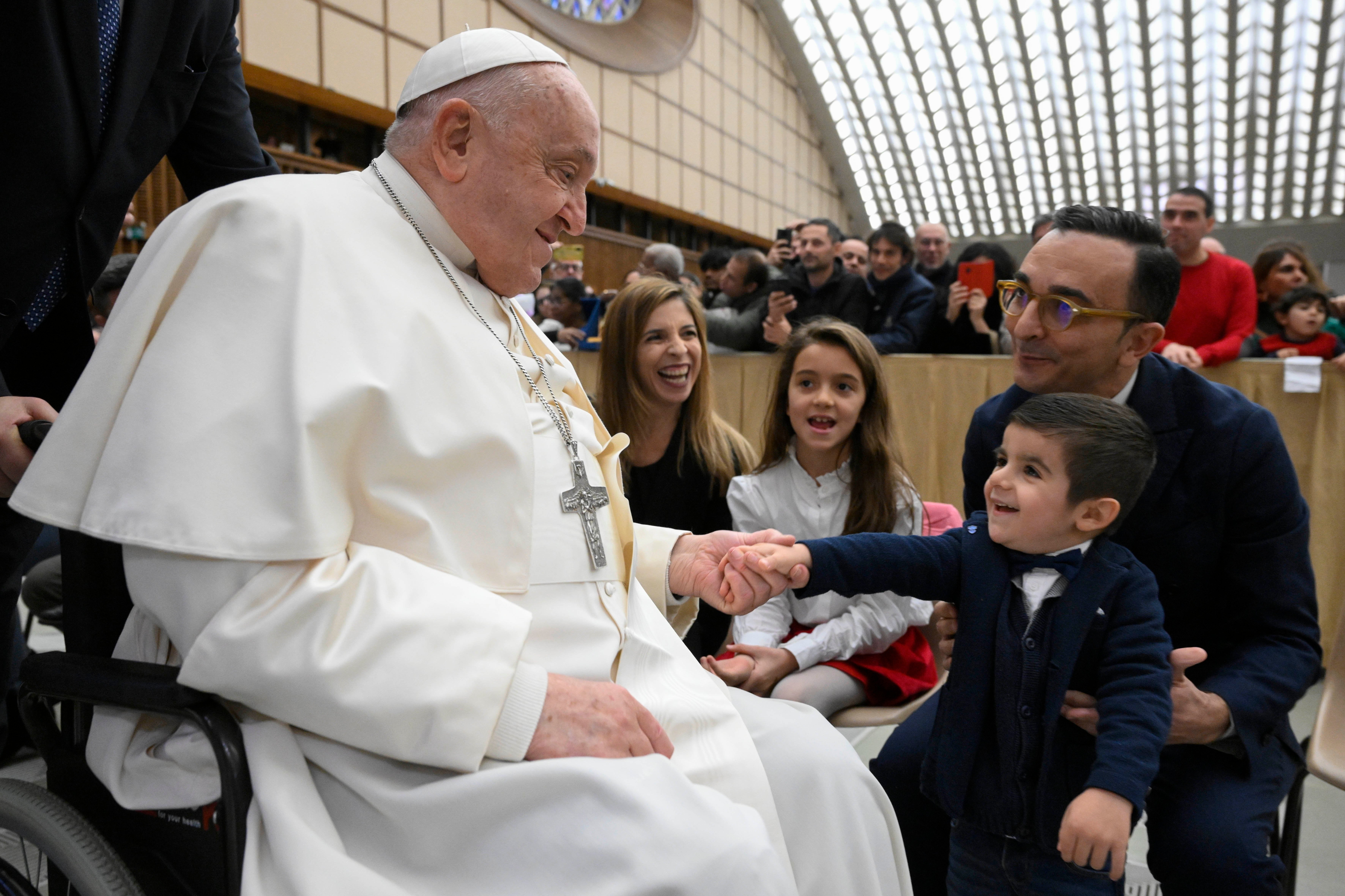 Pope Francis shakes hands with a little boy