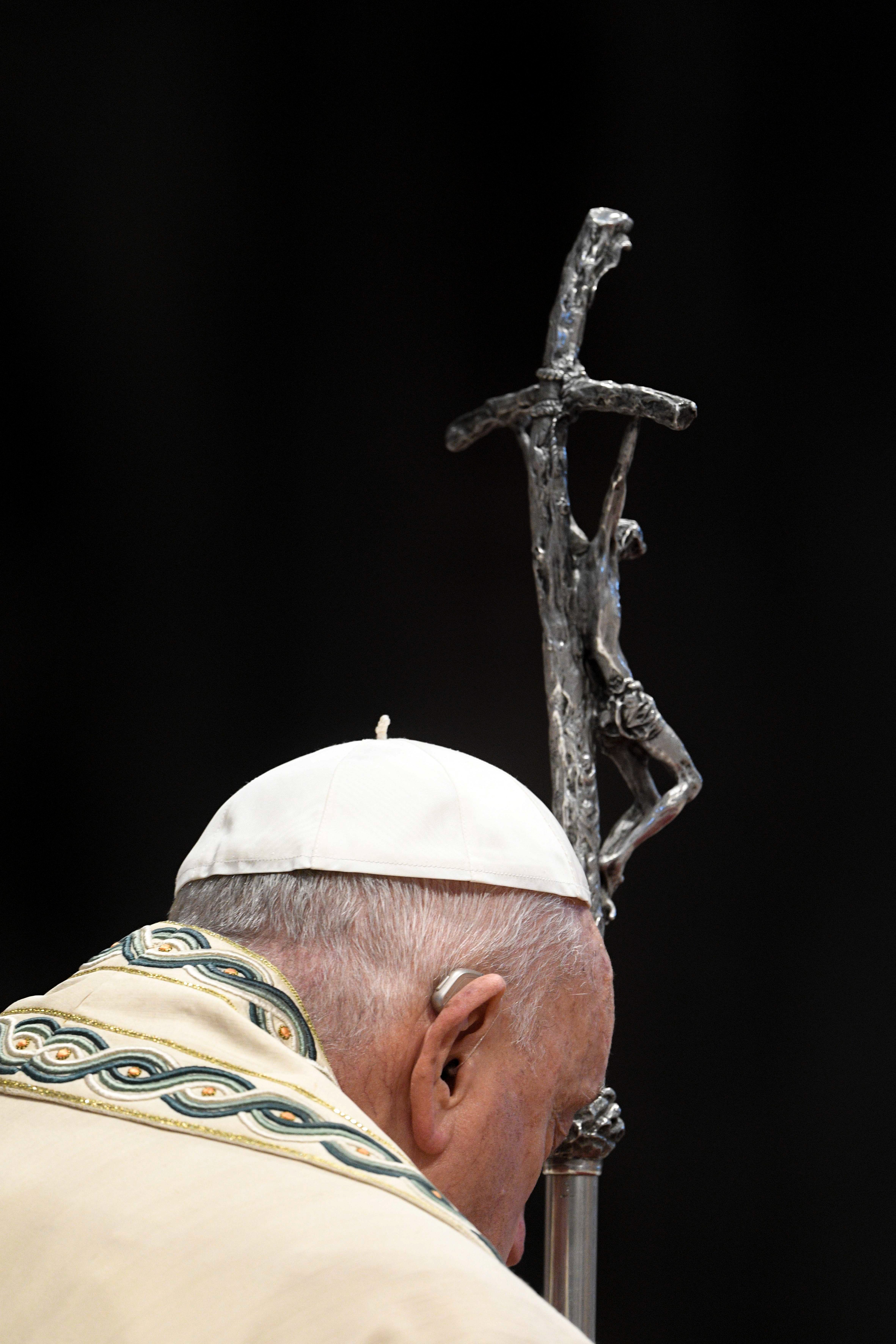 Pope Francis prays as he holds his crosier during Mass in St. Peter's Basilica.