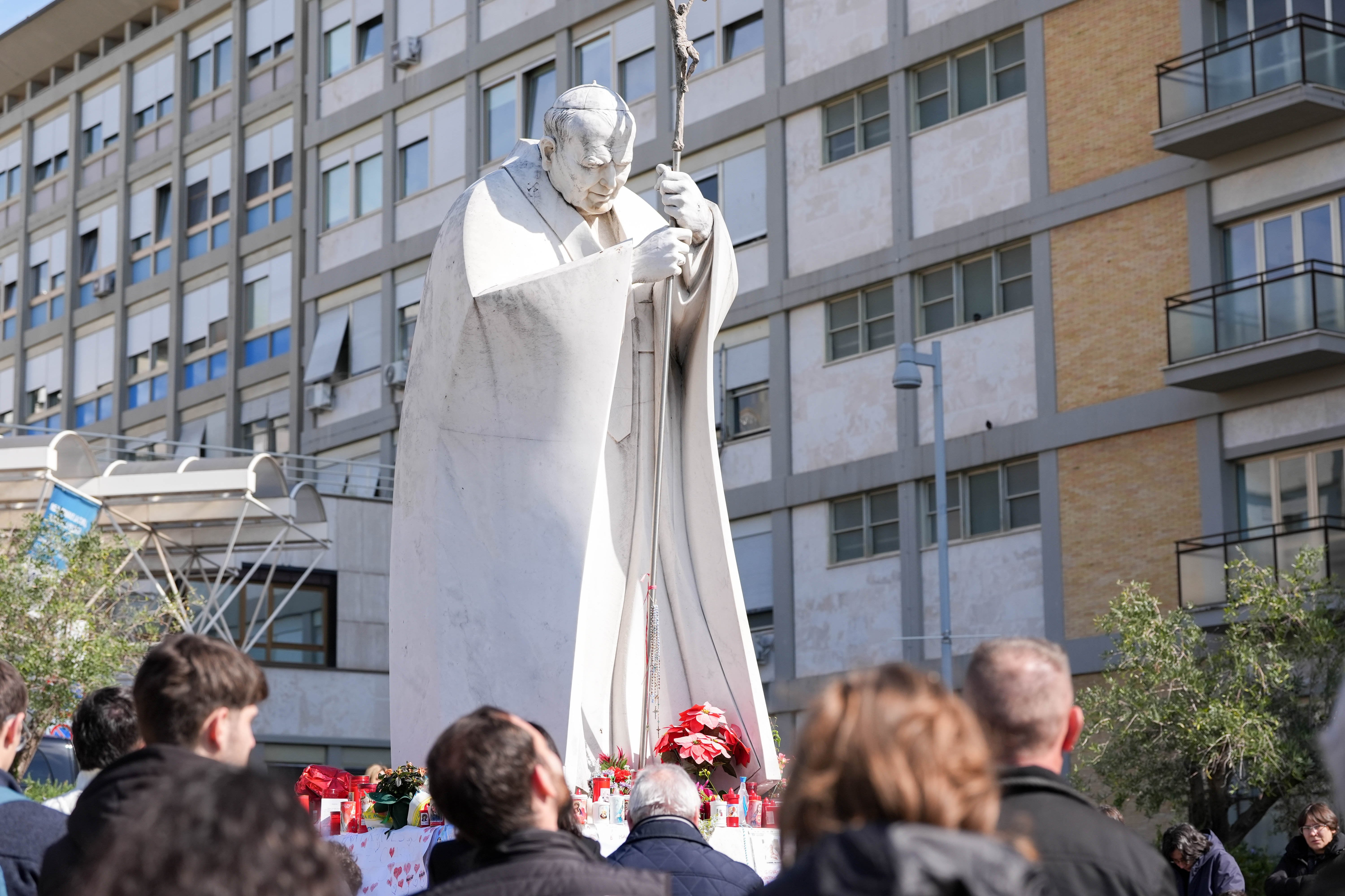 Young people pray outside a hospital.