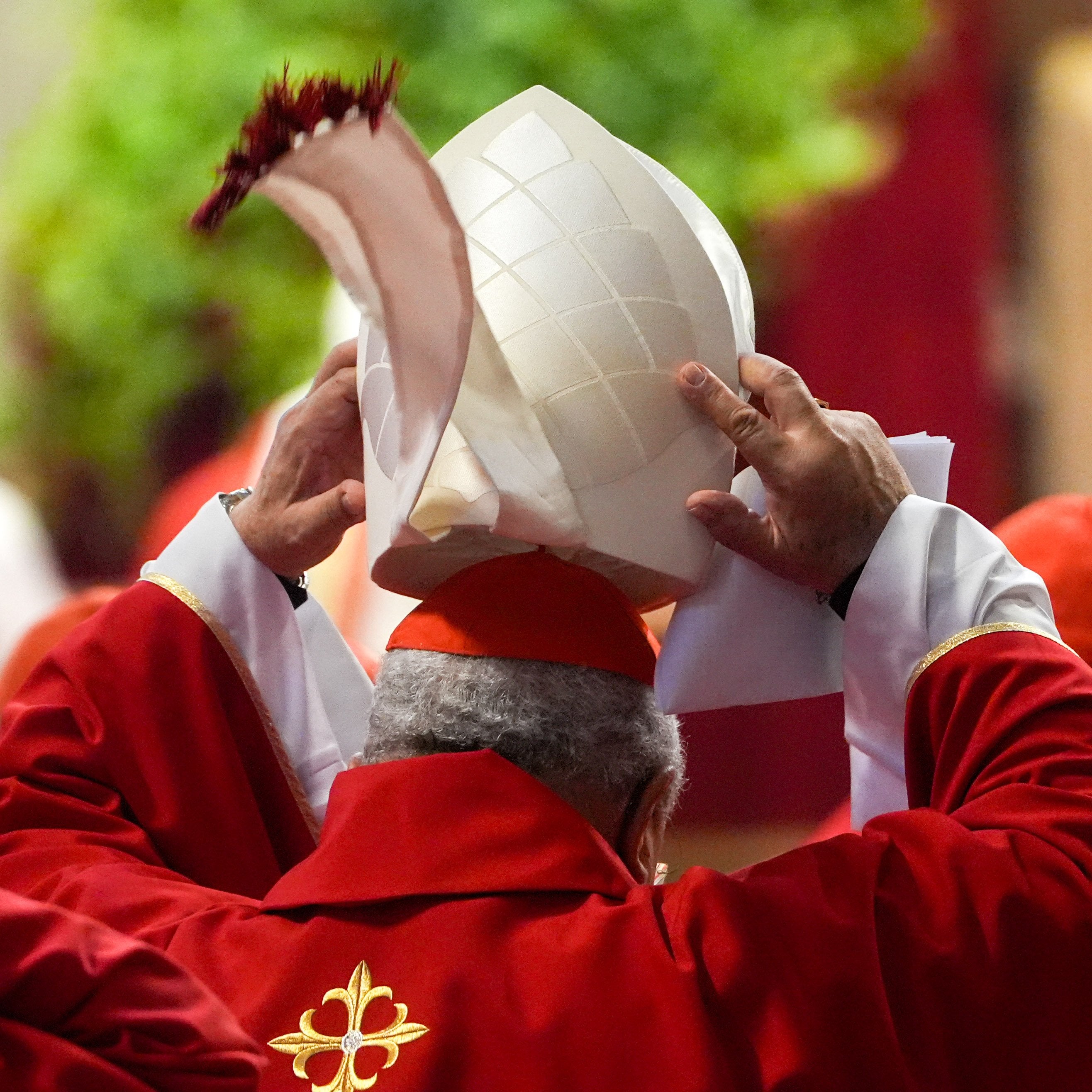 A cardinal adjusts his miter during Mass.