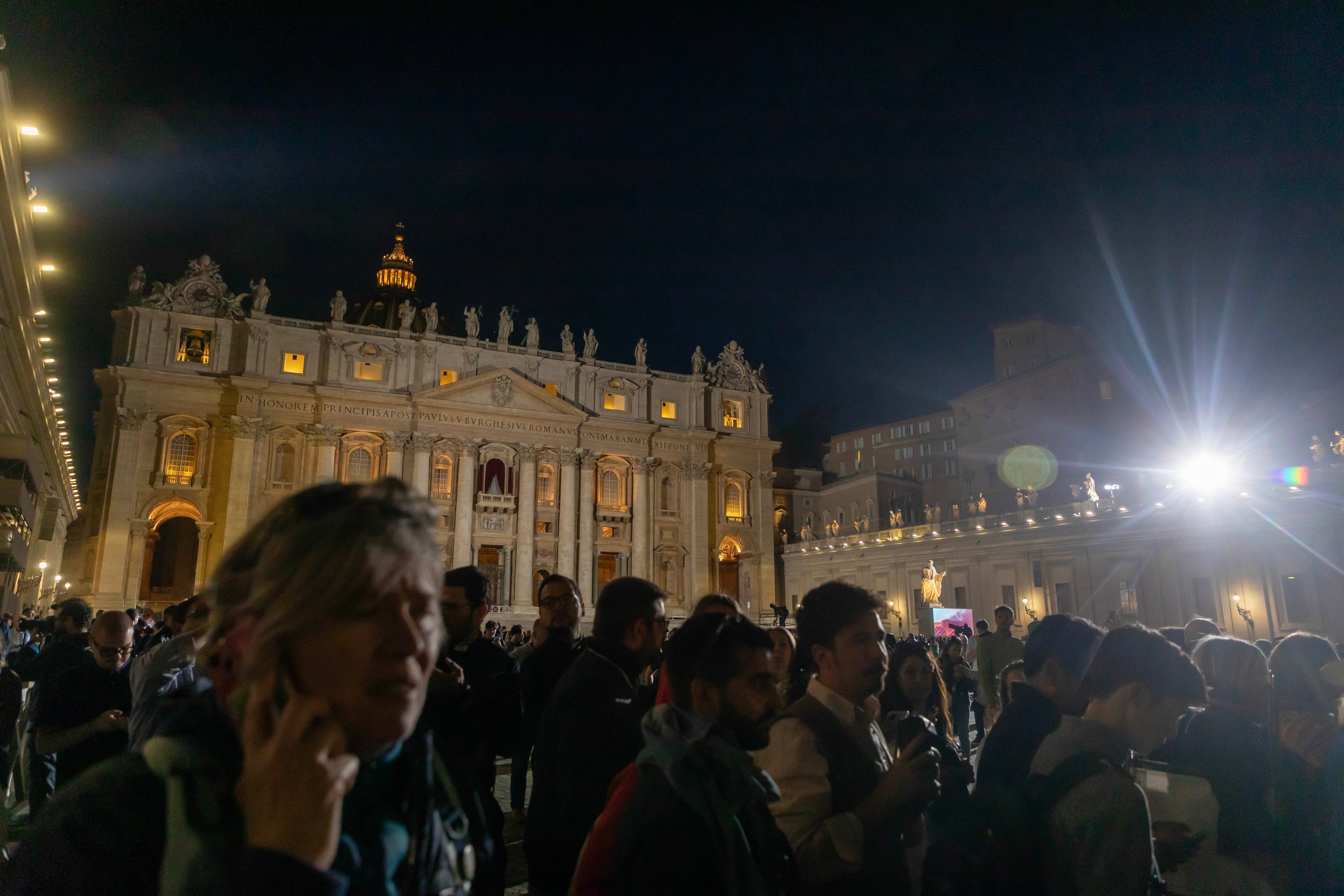People watch from St. Peter's Square as black smoke billows from the chimney atop the Sistine Chapel.
