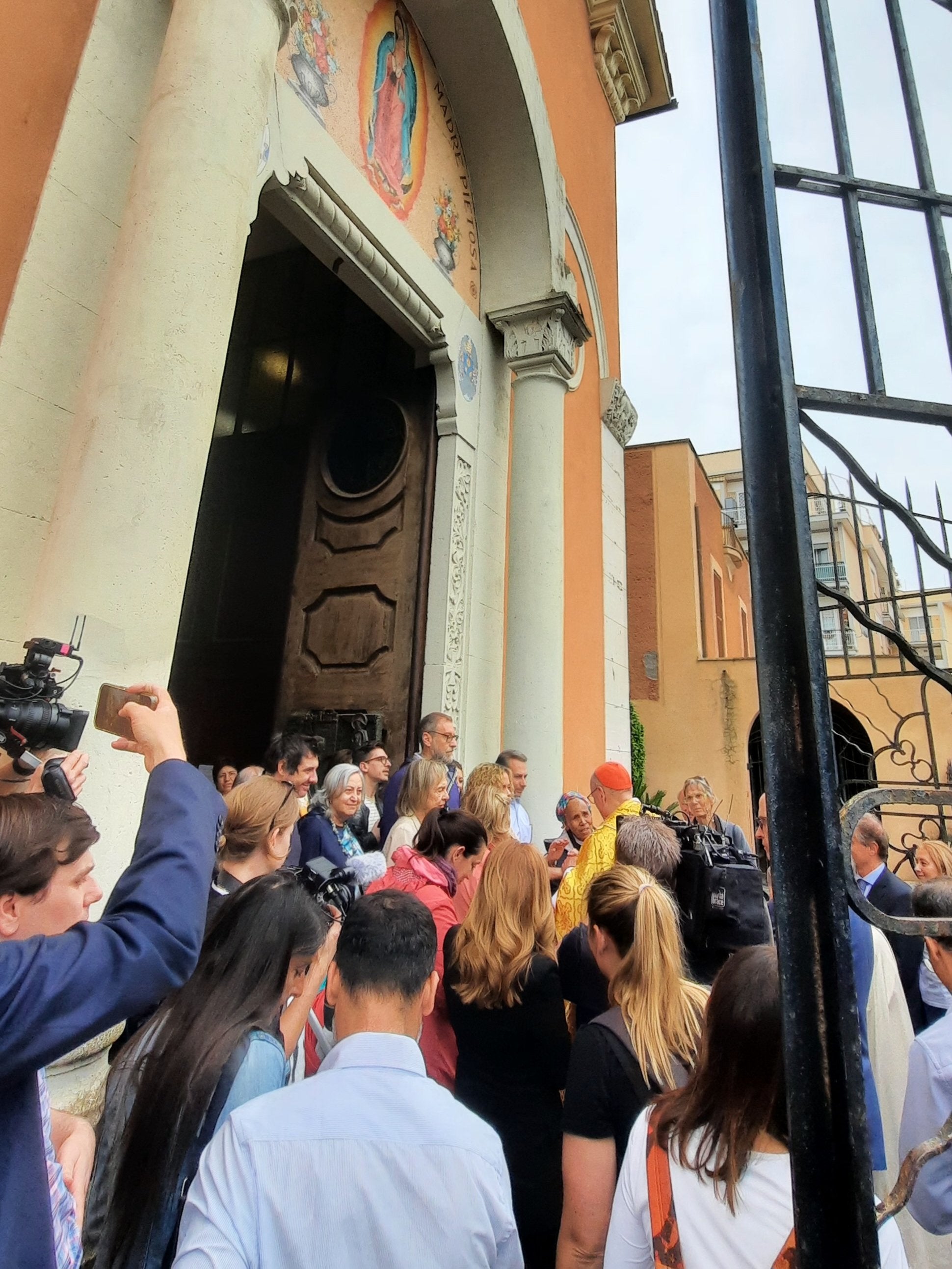 Cardinal Dolan surrounded by parishioners after Mass in Rome