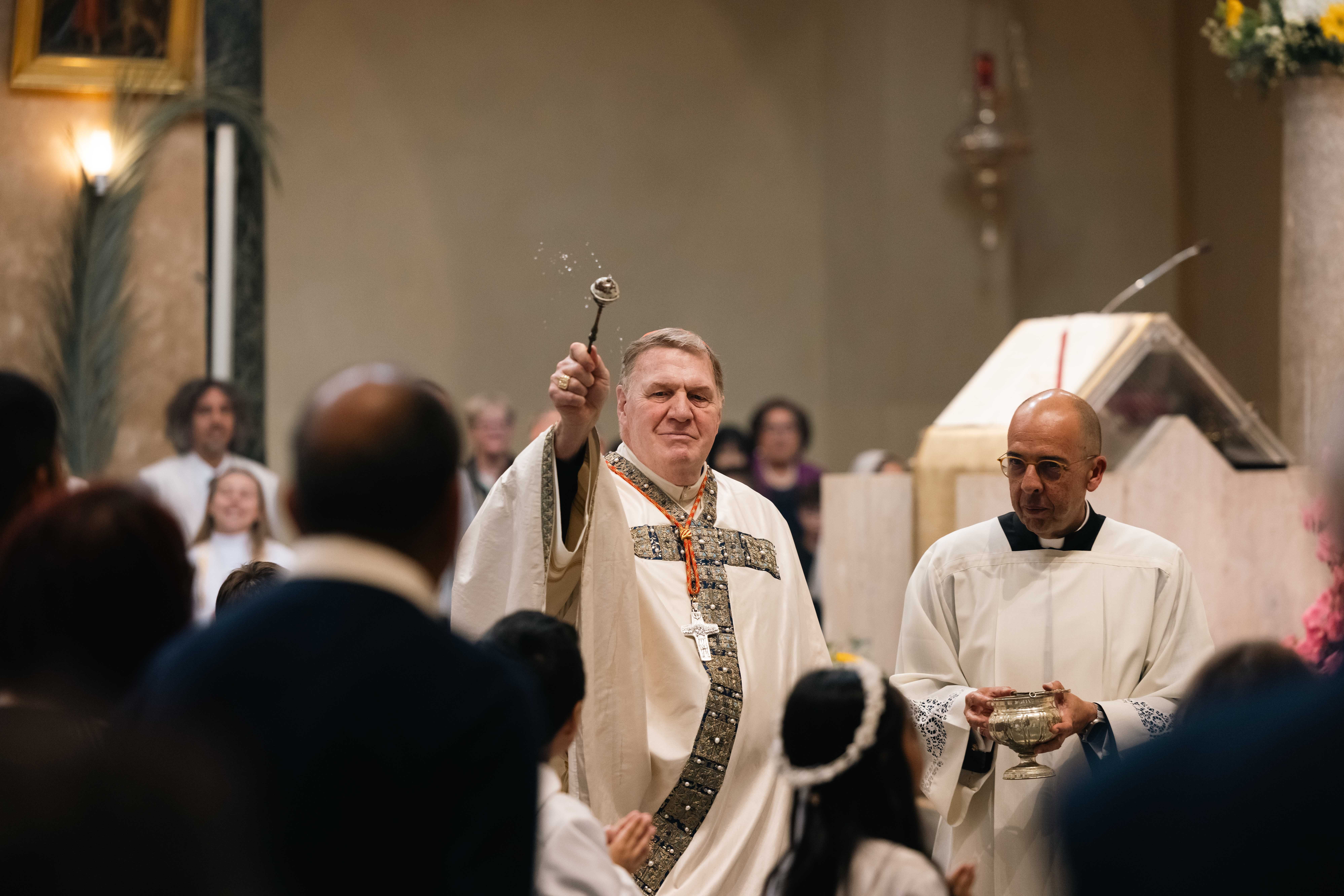 Cardinal Tobin blesses children with holy water