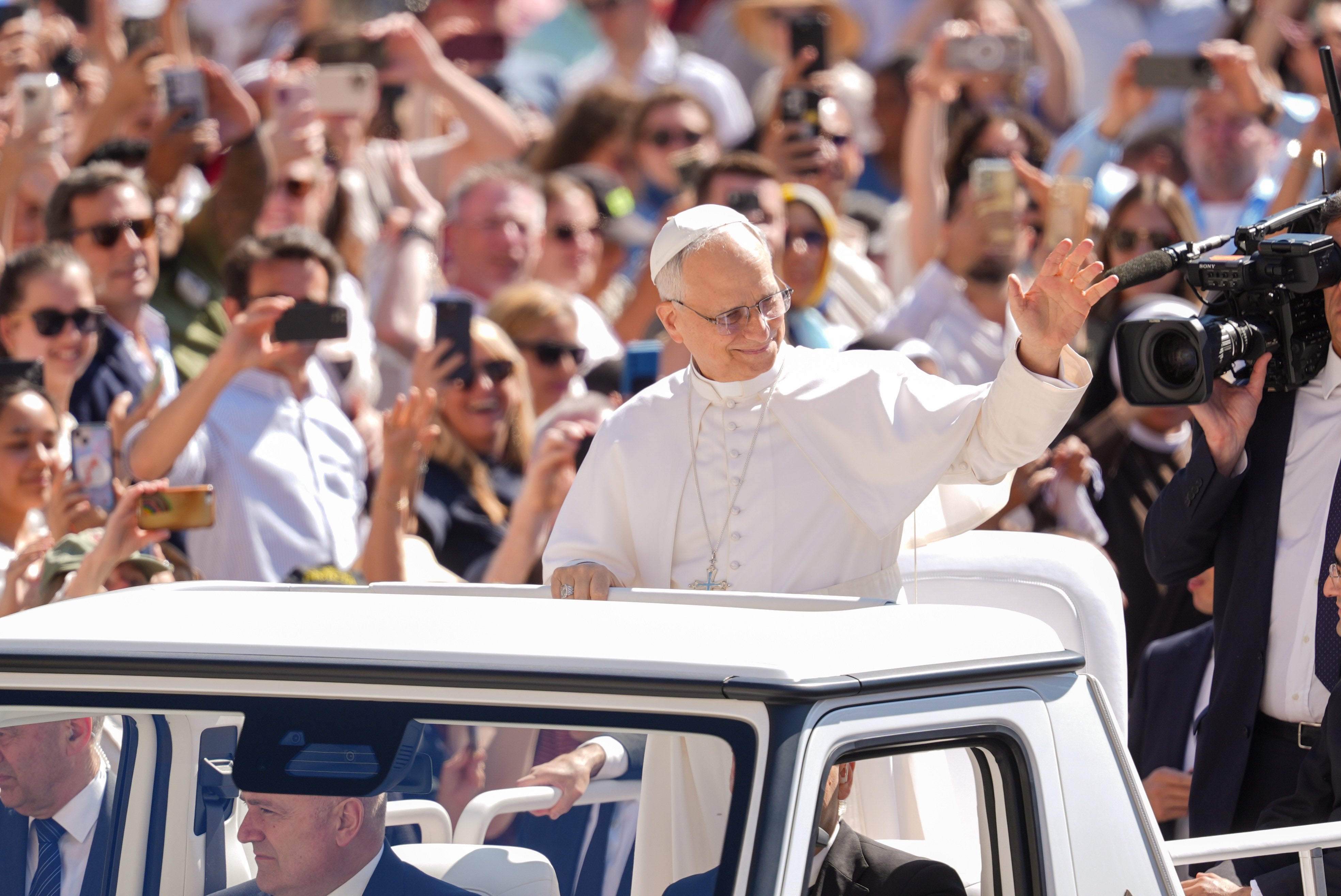 Pope Leo XIV waves from the popemobile