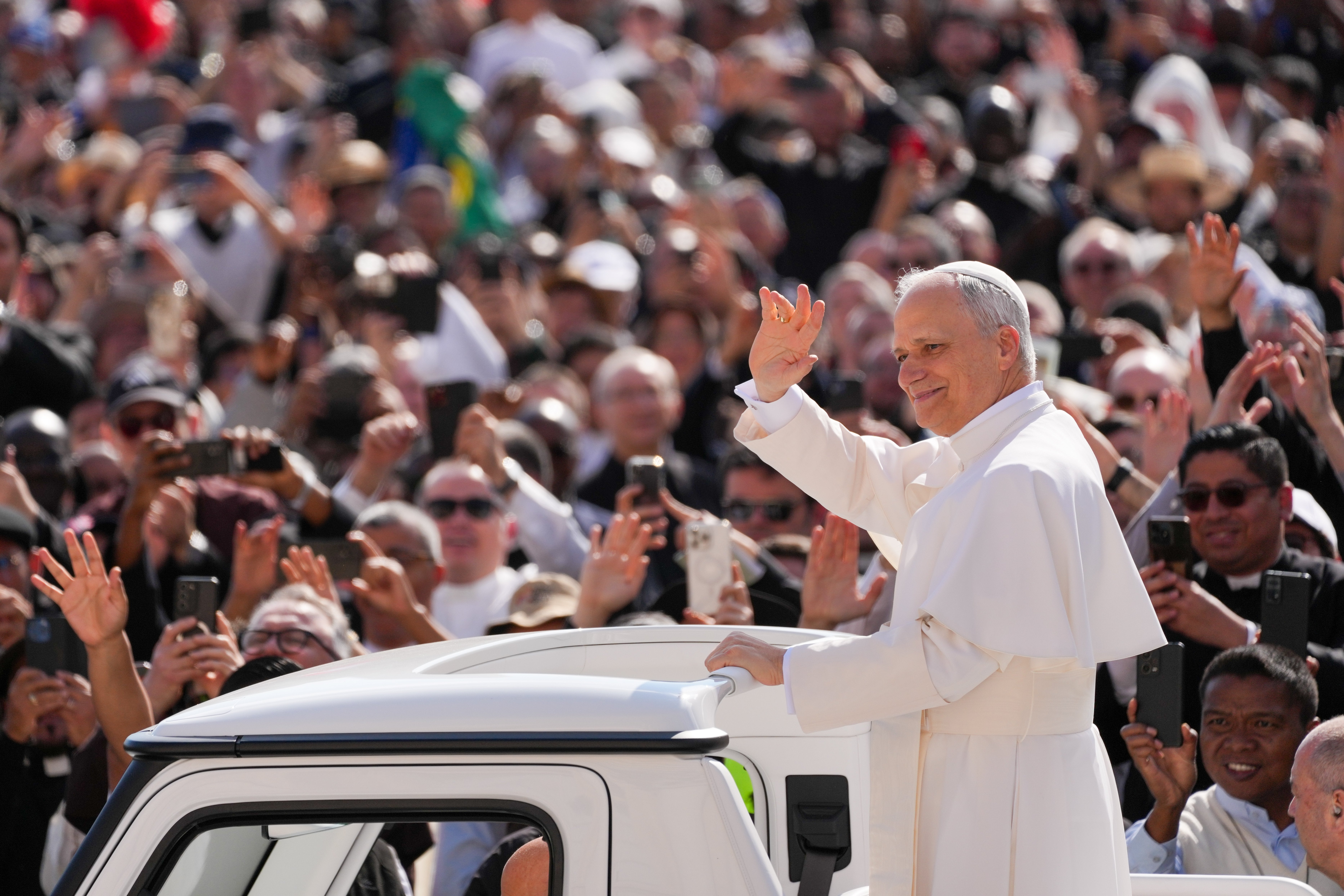 Pope Leo XIV greets the faithful while riding the popemobile through St. Peter's Square.