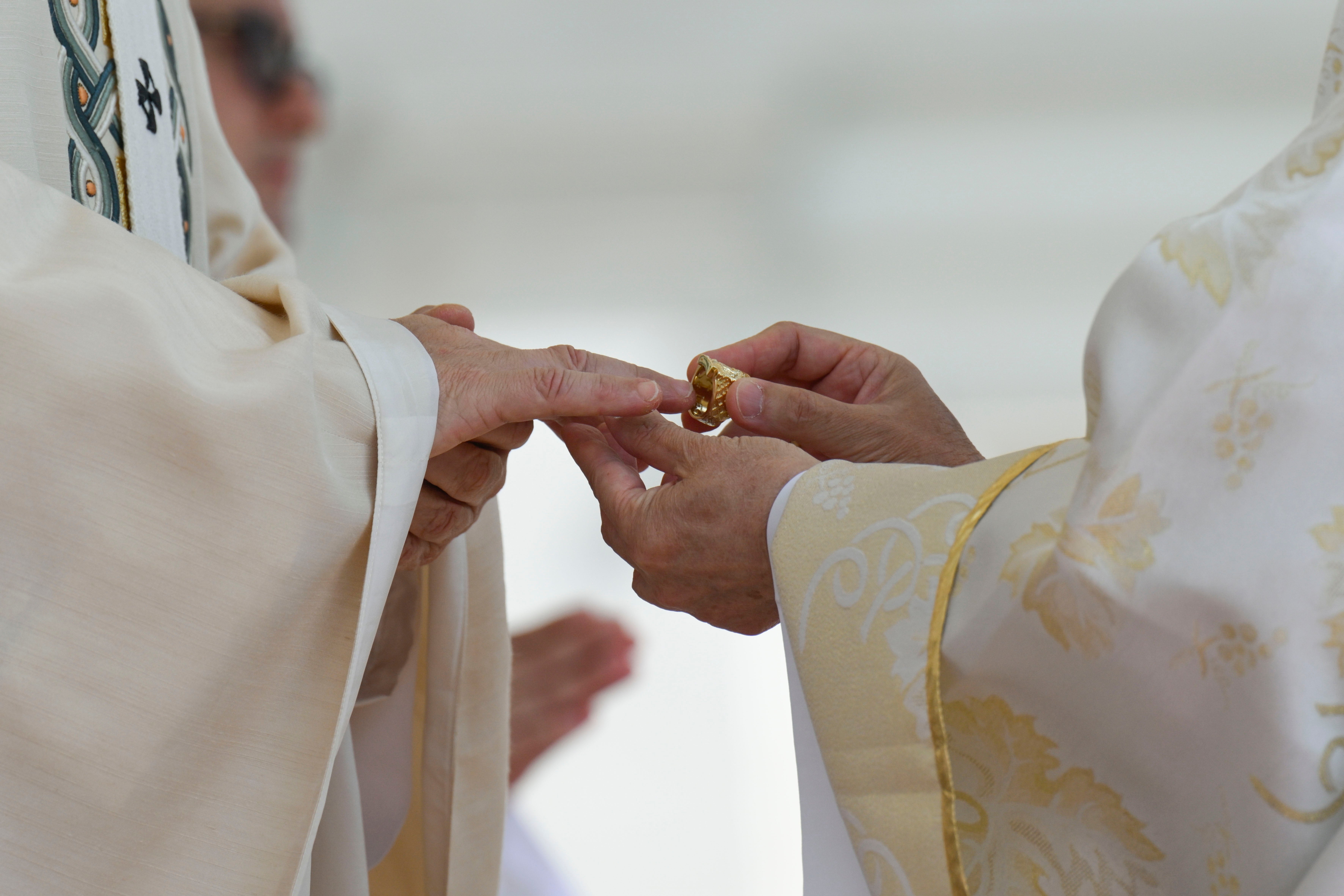 Pope Leo XIV, left, receives the fisherman's ring, symbolizing his role as successor to St. Peter.