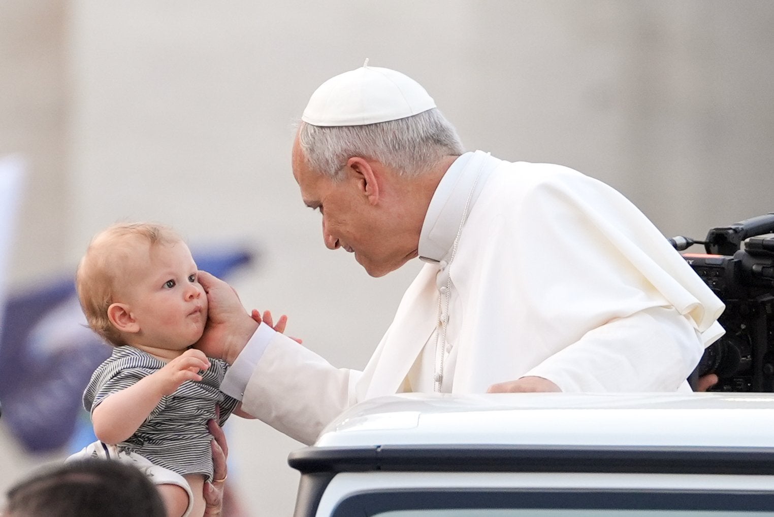 Pope Leo XIV blesses a child