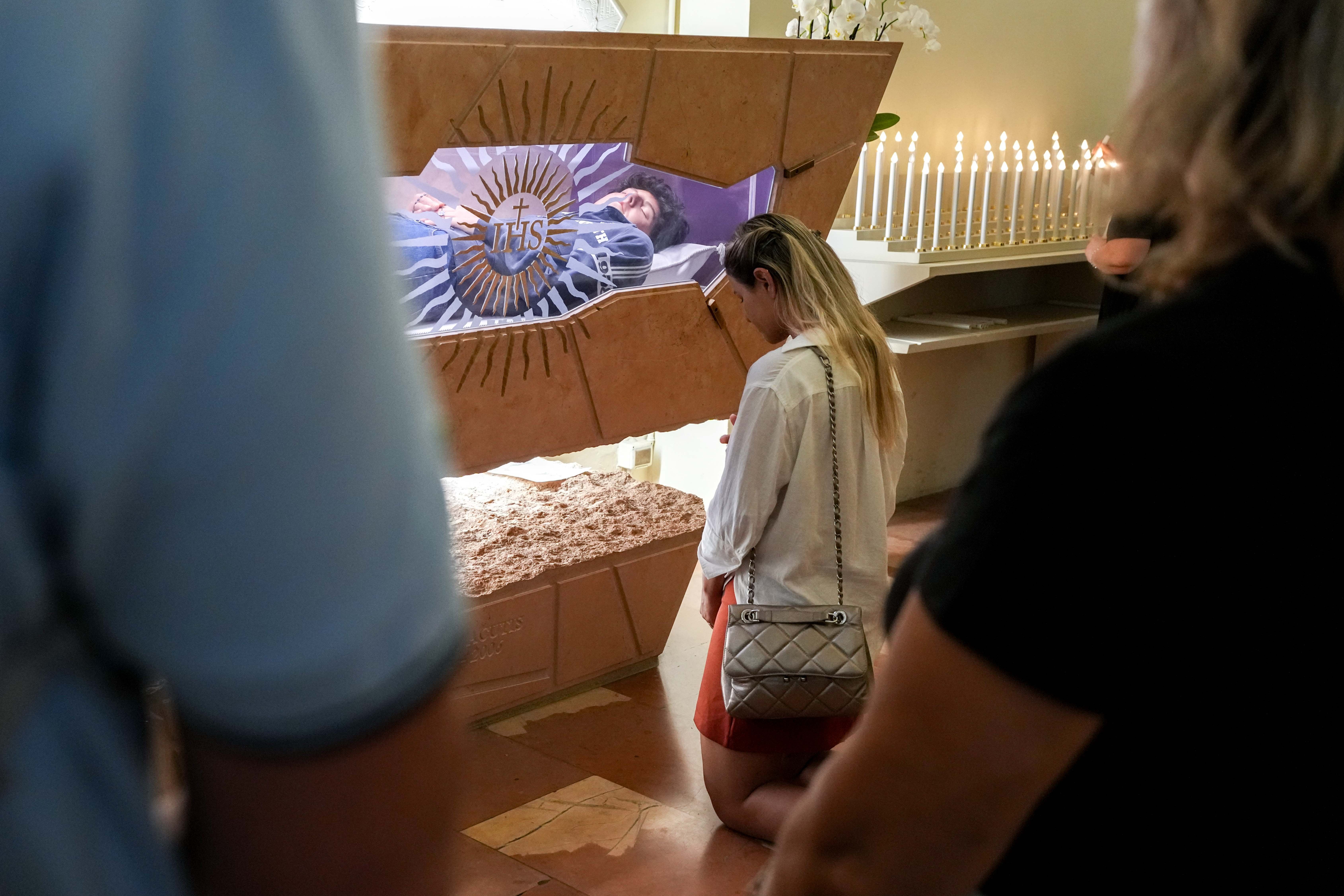 A woman prays at the tomb of Blessed Carlo Acutis in Assisi
