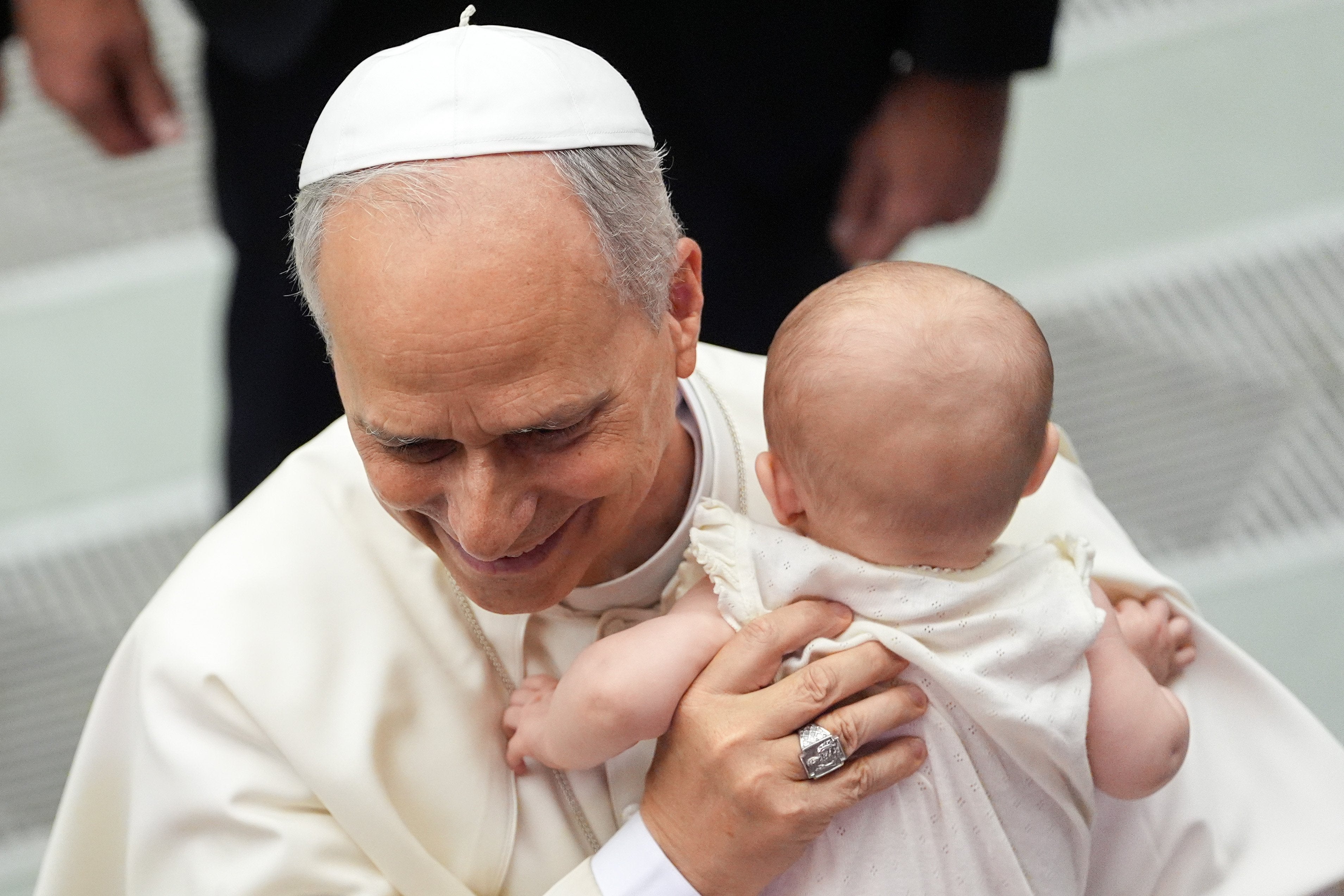 Pope Leo XIV holds a baby at his general audience