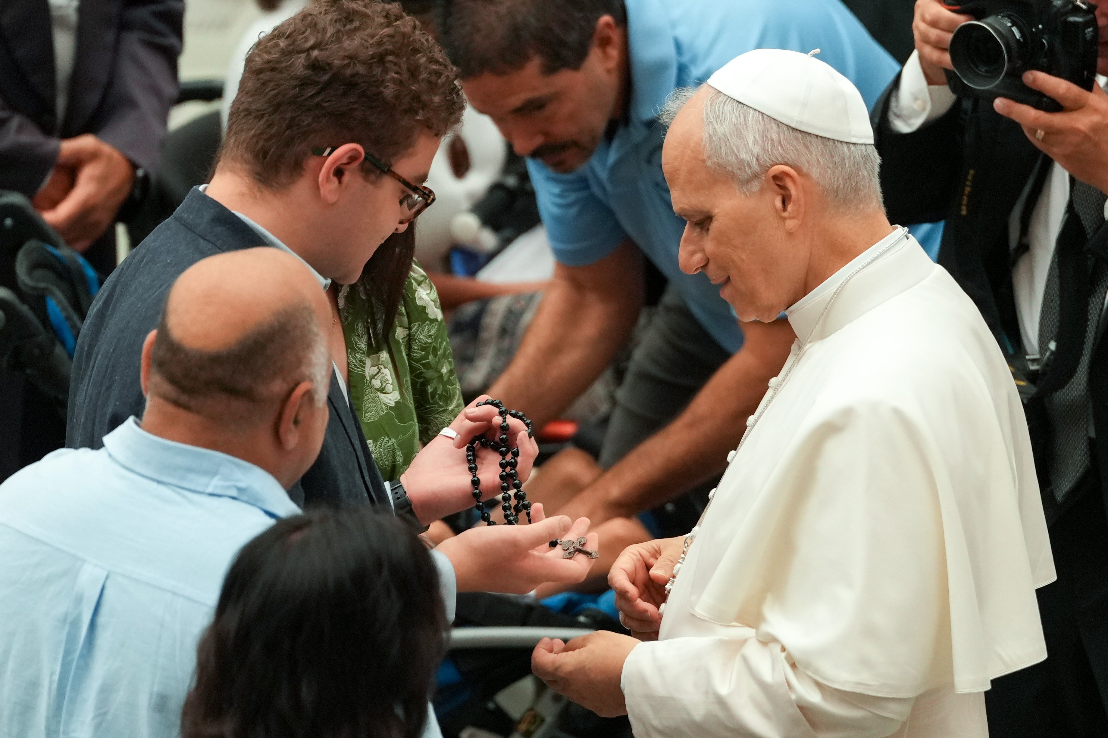Pope Leo blesses a young man's rosary