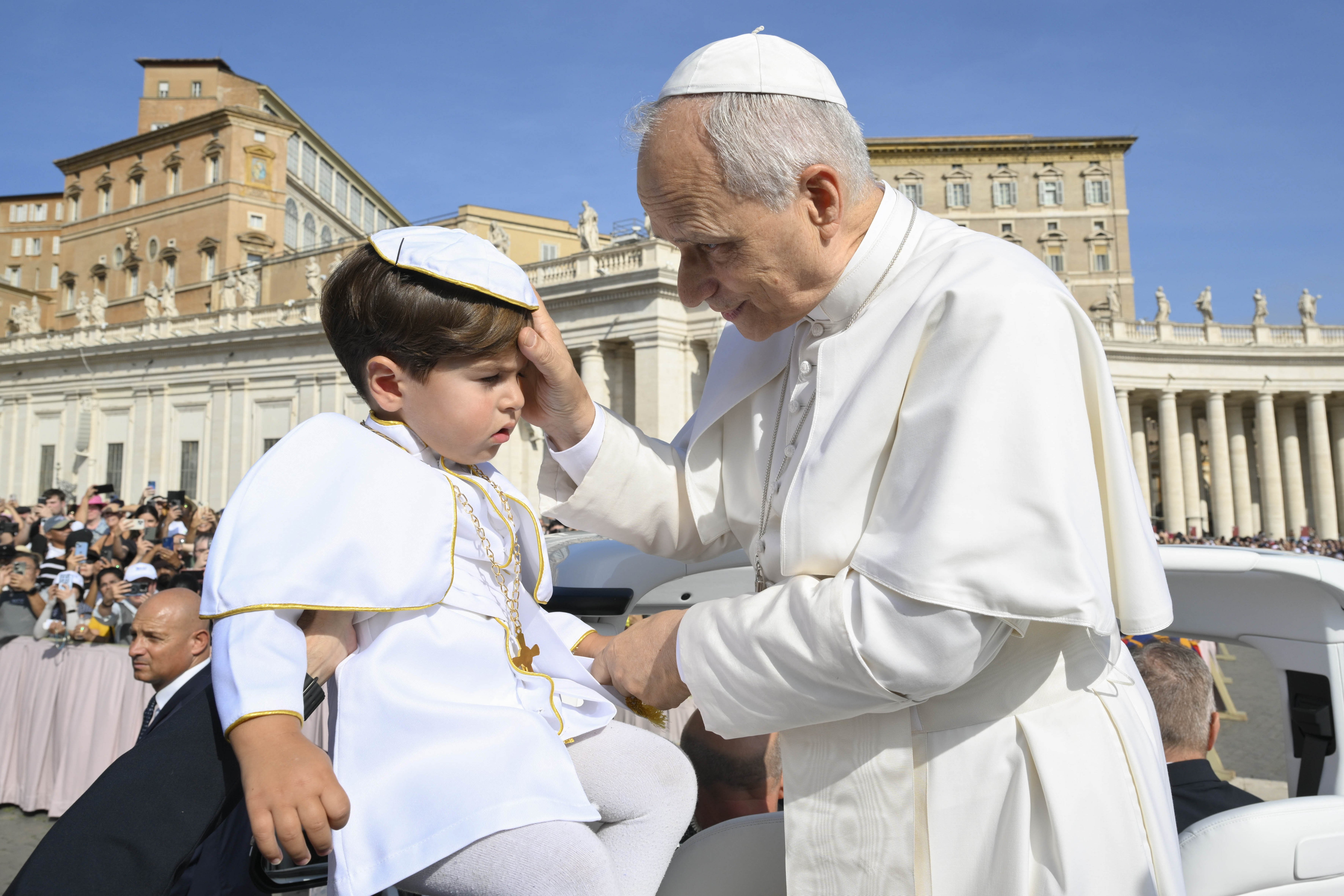 Pope Leo greets a child dressed as the pope