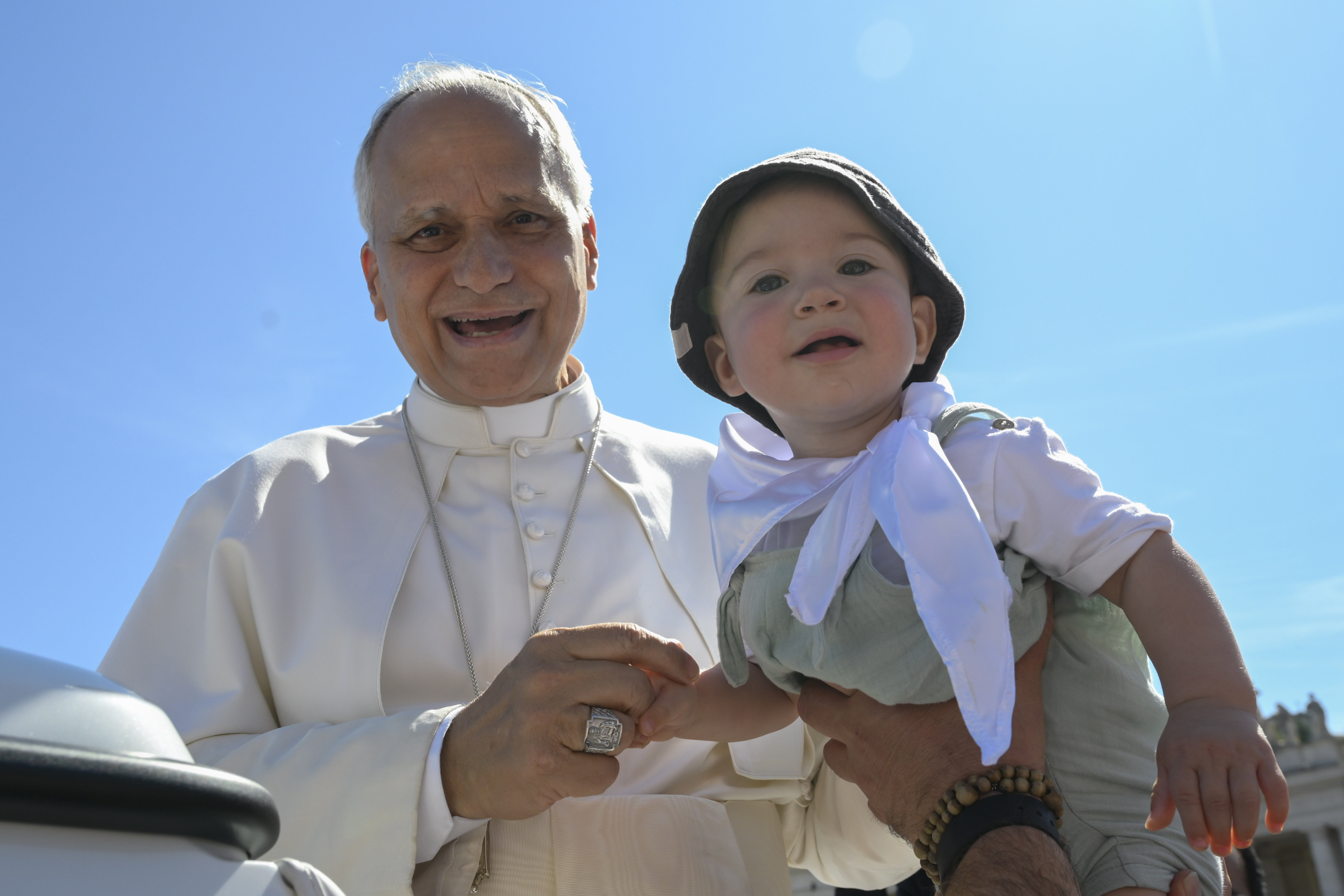 Pope Leo smiles after blessing a child